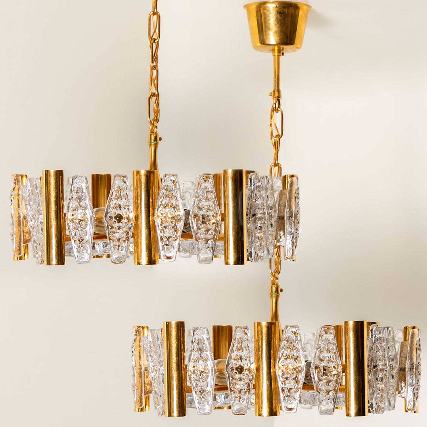This stunning large pendant chandelier with 30 glass shades and brass details was produced in the 1960s by the iconic firm of Orrefors in Europe, Sweden. Around 1960. Beautifully carved clear frosted glass shades on brass fittings. The light bulbs