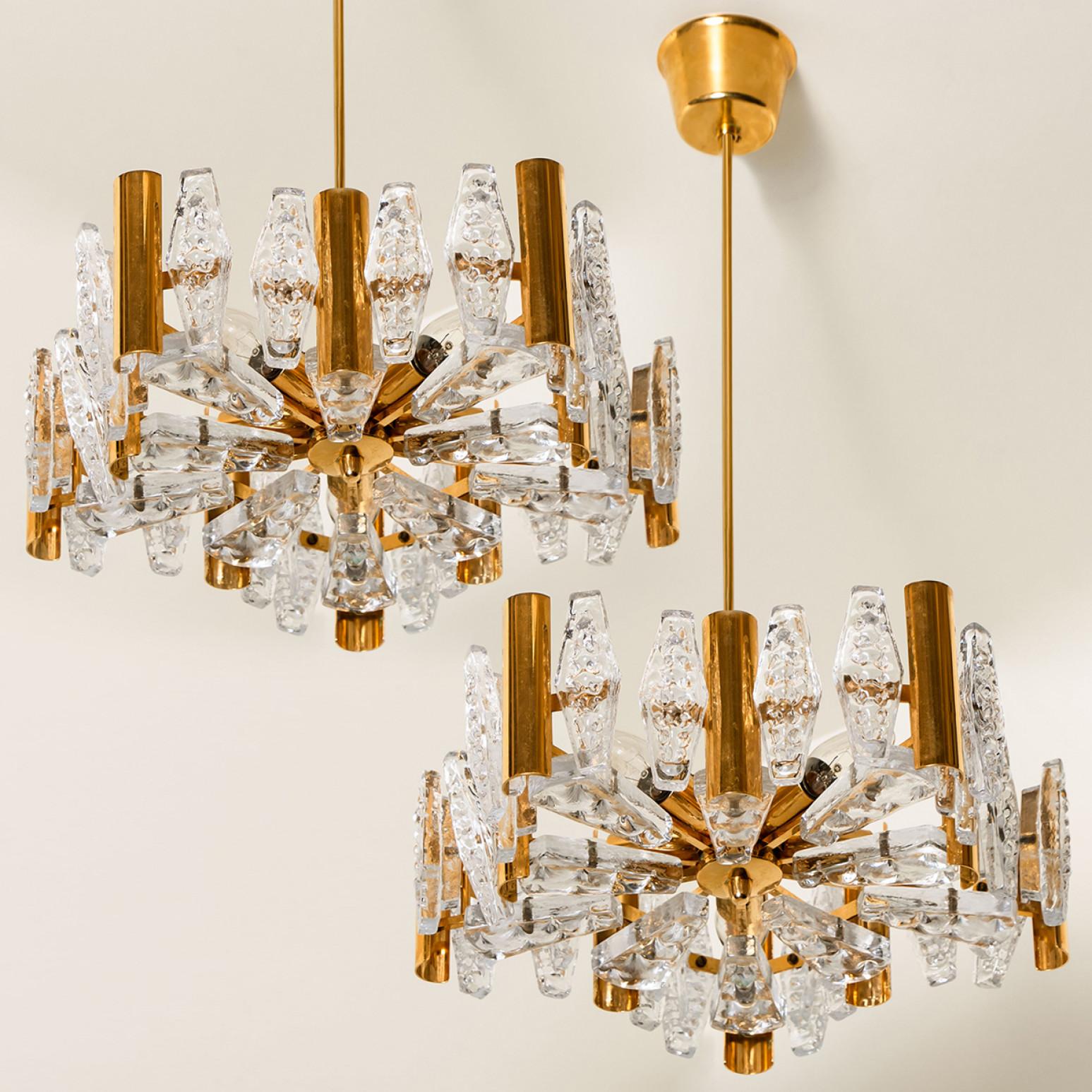 Questo straordinario lampadario a sospensione di grandi dimensioni con 30 paralumi in vetro e dettagli in ottone è stato prodotto negli anni '60 dall'iconica azienda Orrefors in Europa, Svezia. Intorno al 1960. Paralumi in vetro smerigliato