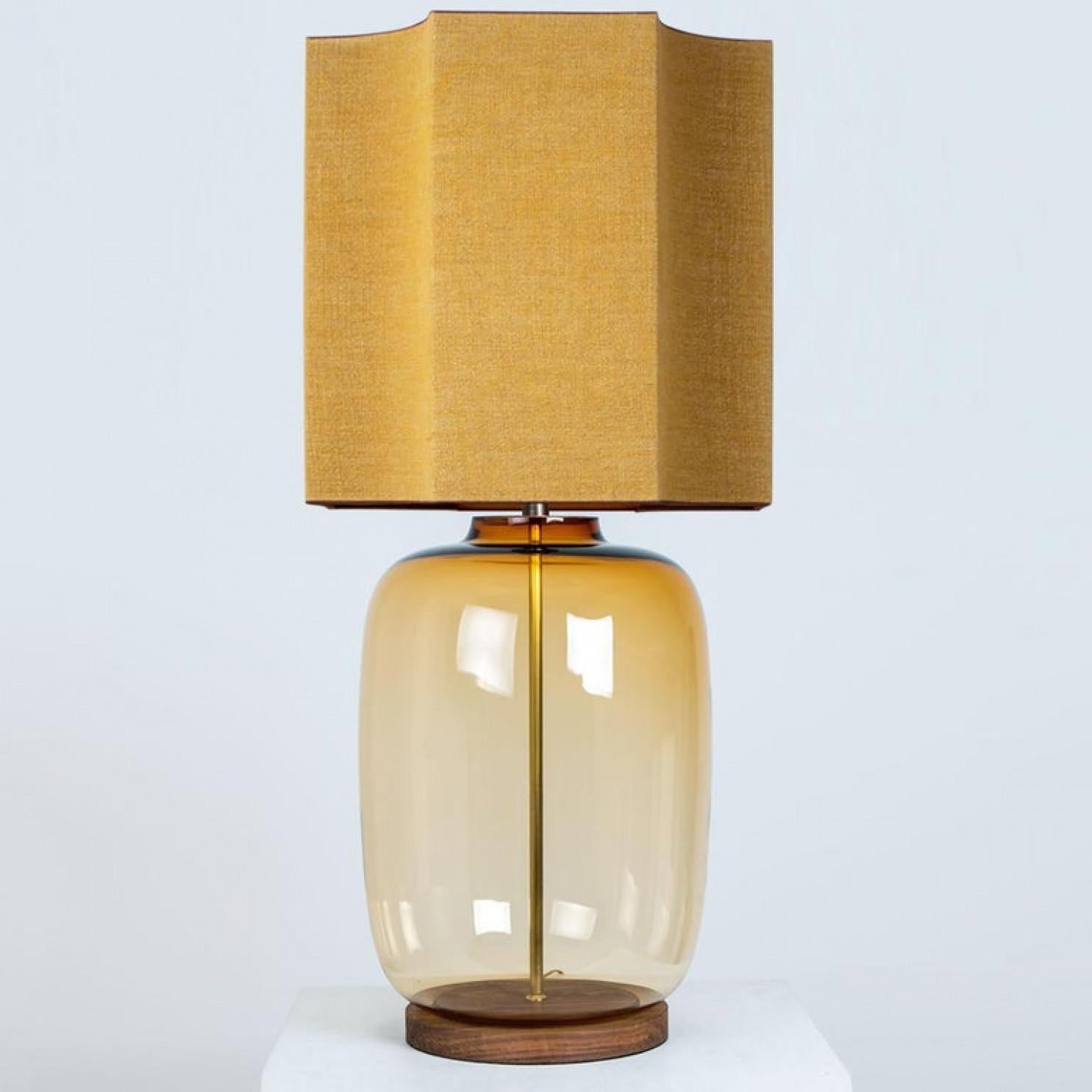 A unique Minimalist timeless design. Each extra large glass table lamp features a yellow exceptional transparent shaped base with a solid burr walnut foot with old brass accents and a brass rod running through the center. Enhancing the light and