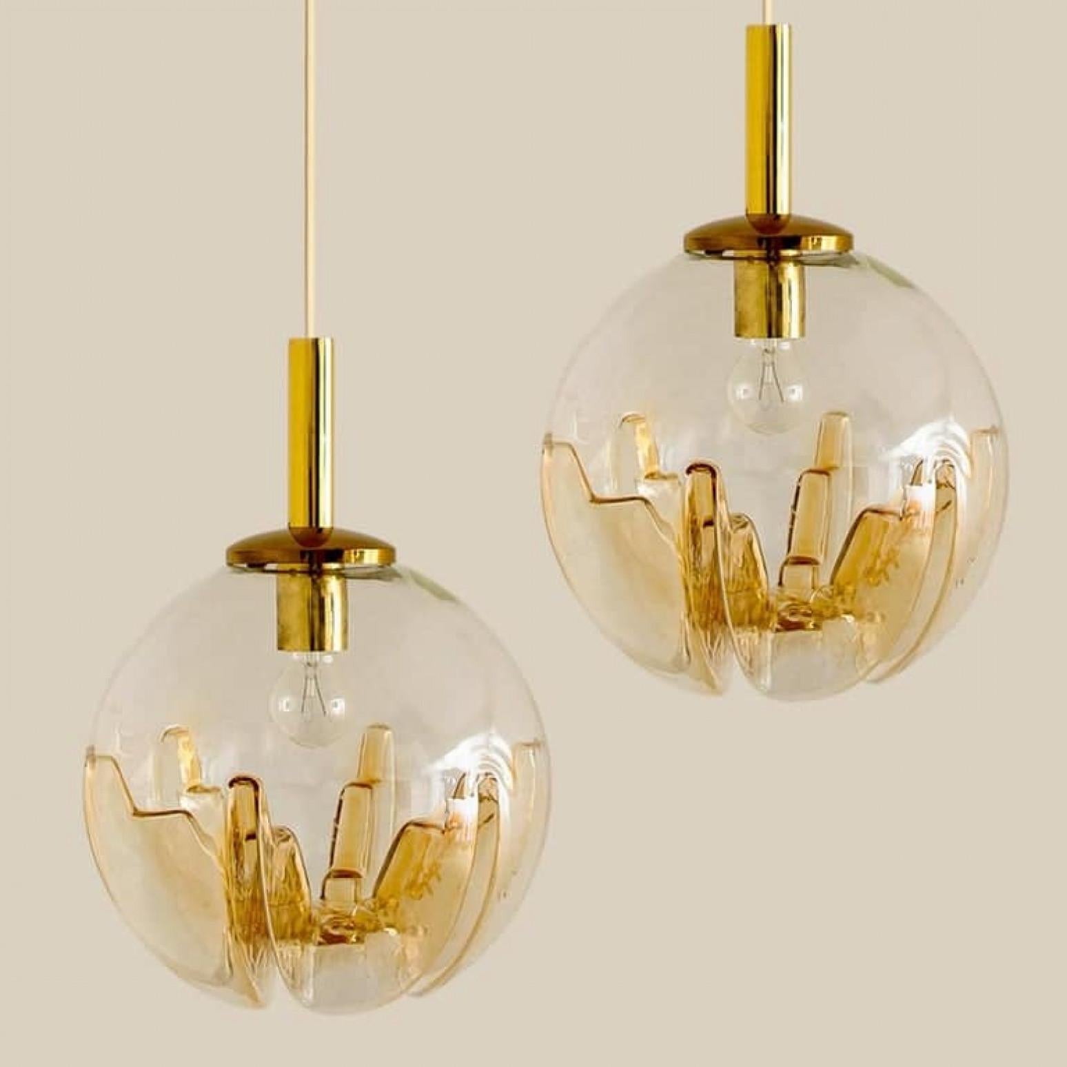 1 dei 2 ciondoli a globo di Murano, prodotto in Italia nel 1970, questo raffinato ciondolo a globo è stato realizzato dal celebre creatore Mazzega Murano in Italia, intorno al 1970. Presenta una forma globosa in vetro trasparente con inflessioni