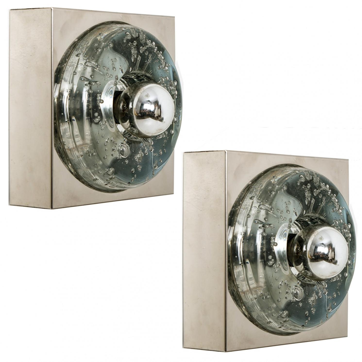 1 delle 2 luci Doria sono realizzate in vetro soffiato a mano su una piastra quadrata color argento. Il vetro crea un piacevole effetto di illuminazione sul soffitto, sul tavolo o sulla parete. Ogni lampada ha un attacco E14 (Max 30 Watt)

Può
