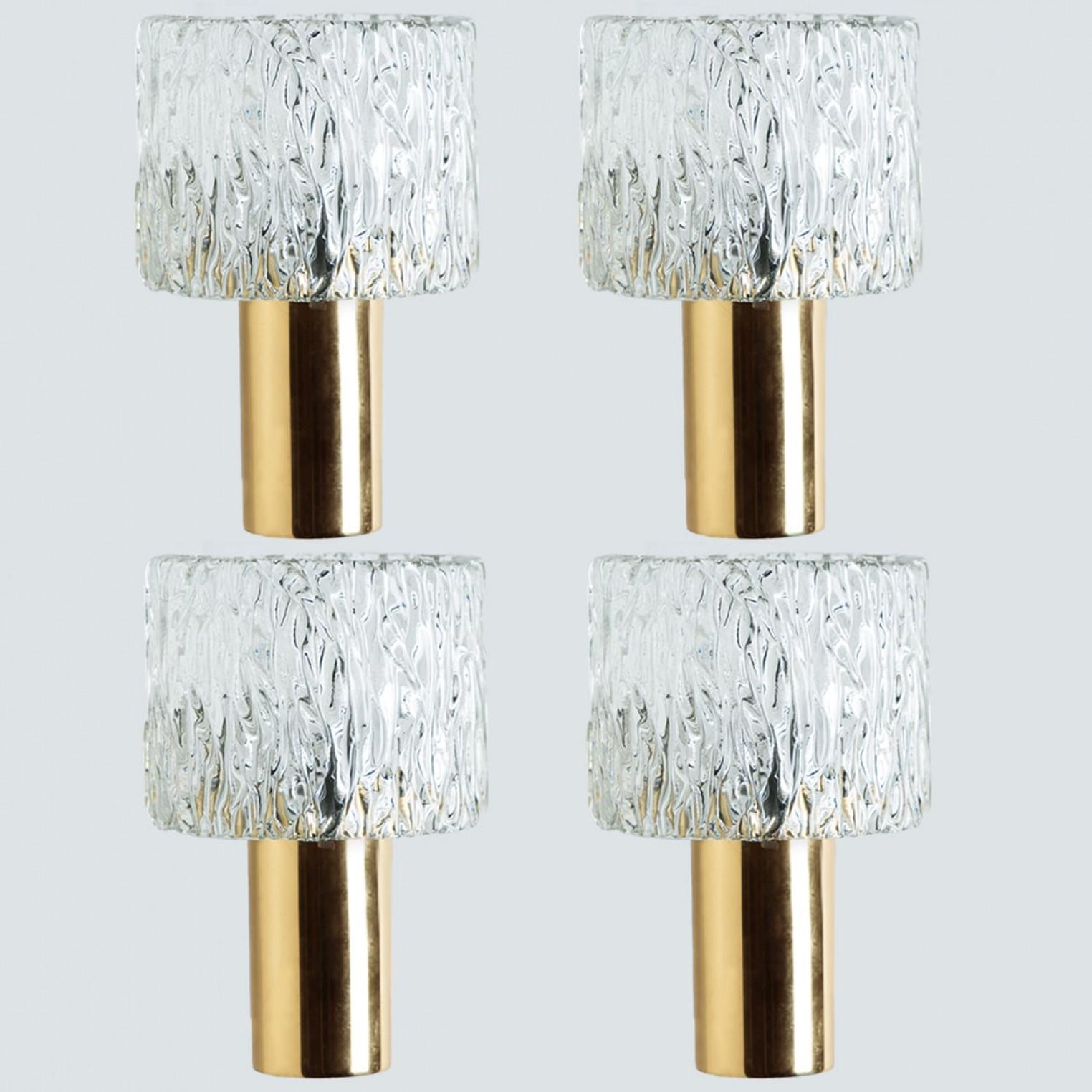 1 of the 2 pairs high-end wall lights with a glass shade and brass frame. The light fixtures are produced in the 1960s and designed by Carl Fagerlund.

Beautifully carved wave-like glass shades in a round design on brass fitting and frame. The