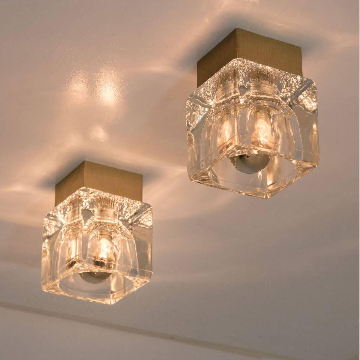 Several high quality Peill & Putzler wall lights brass and glass cubes, circa 1970s, Germany. This sculptural ceiling lights from Peill & Putzler consists 1 clear illuminated glass cube on a square brass frame.

The glass cube beautifully reflects a