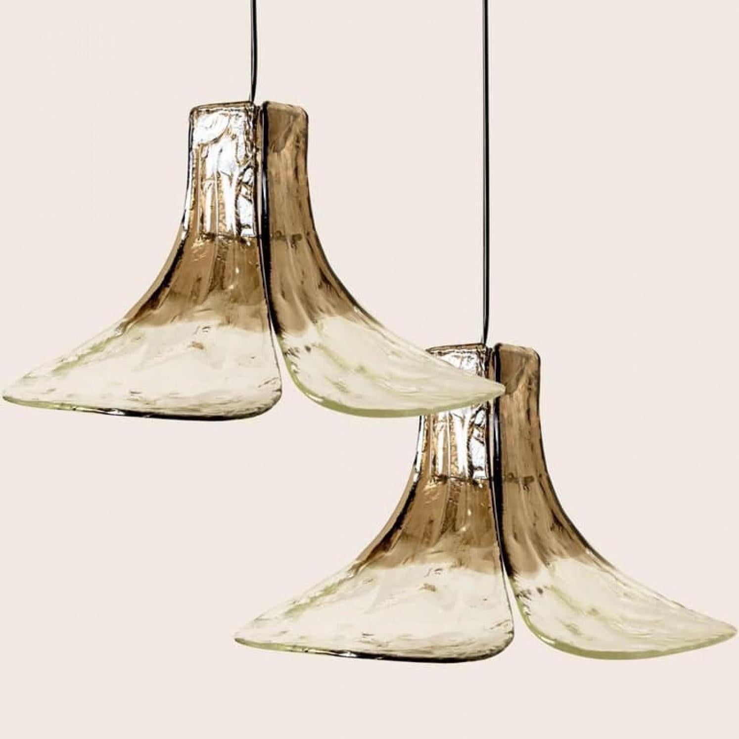 1 der 2 Pendelleuchten von Carlo Nason für Mazzega.
Vier kristallklare und geräucherte Blätter bilden dieses schöne Stück aus dickem handgefertigtem Murano-Glas.

Maße: H 43 cm (16.93