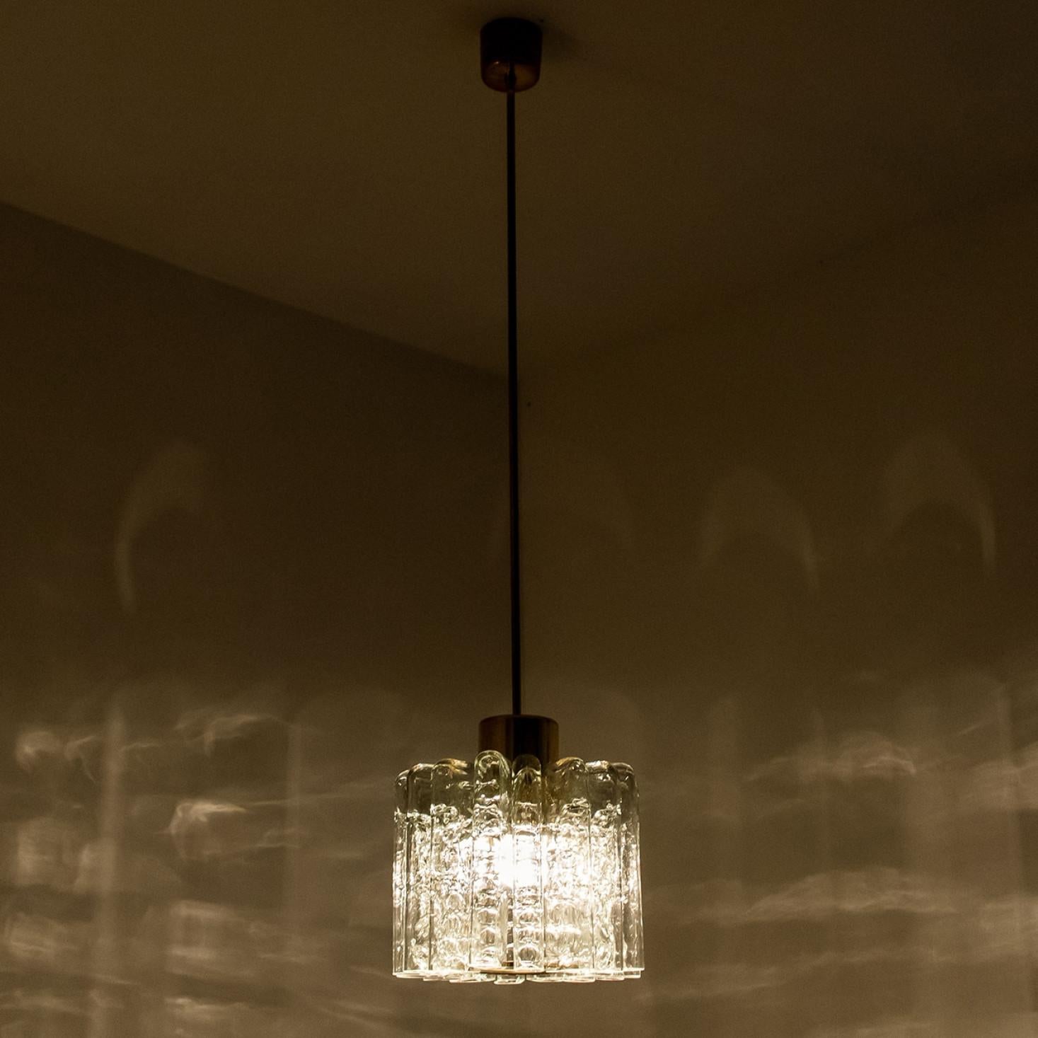 Lampada a sospensione in vetro a forma di tulipano, prodotta da Doria Leuchten Germany nel 1960 circa.

Questo ciondolo fatto a mano è composto da un'asta di ottone con una serie di bacchette di vetro a forma di tubo testurizzato. Grazie alla