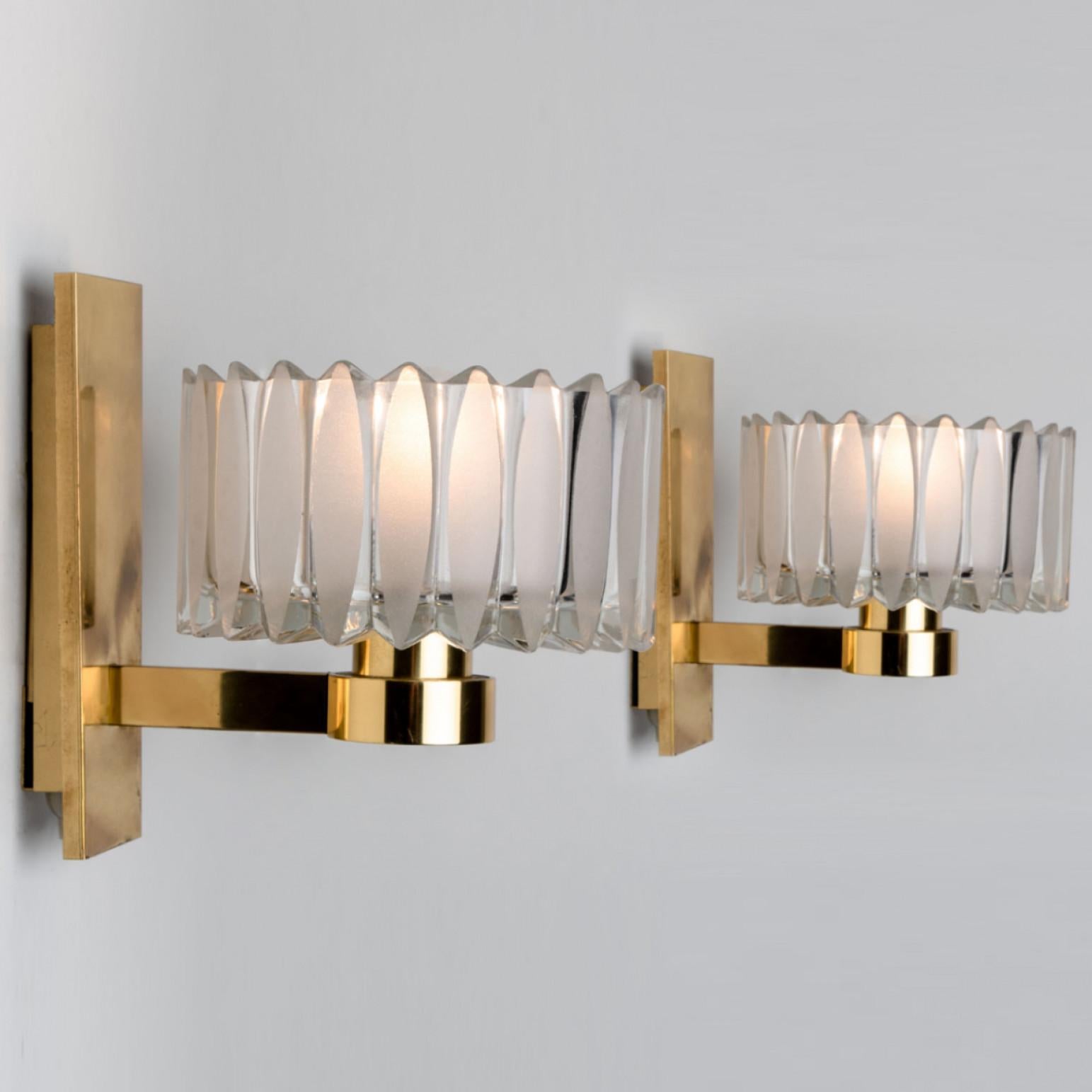 Clean lines to complement all decors. A wonderful high-end Hillebrand wall light fixture with an ellipse shaped pattern glass and brass details.
Designed and manufactured in the 1970s in Germany, Europe.

Each wall sconce holds 1 E14 socket.

Please
