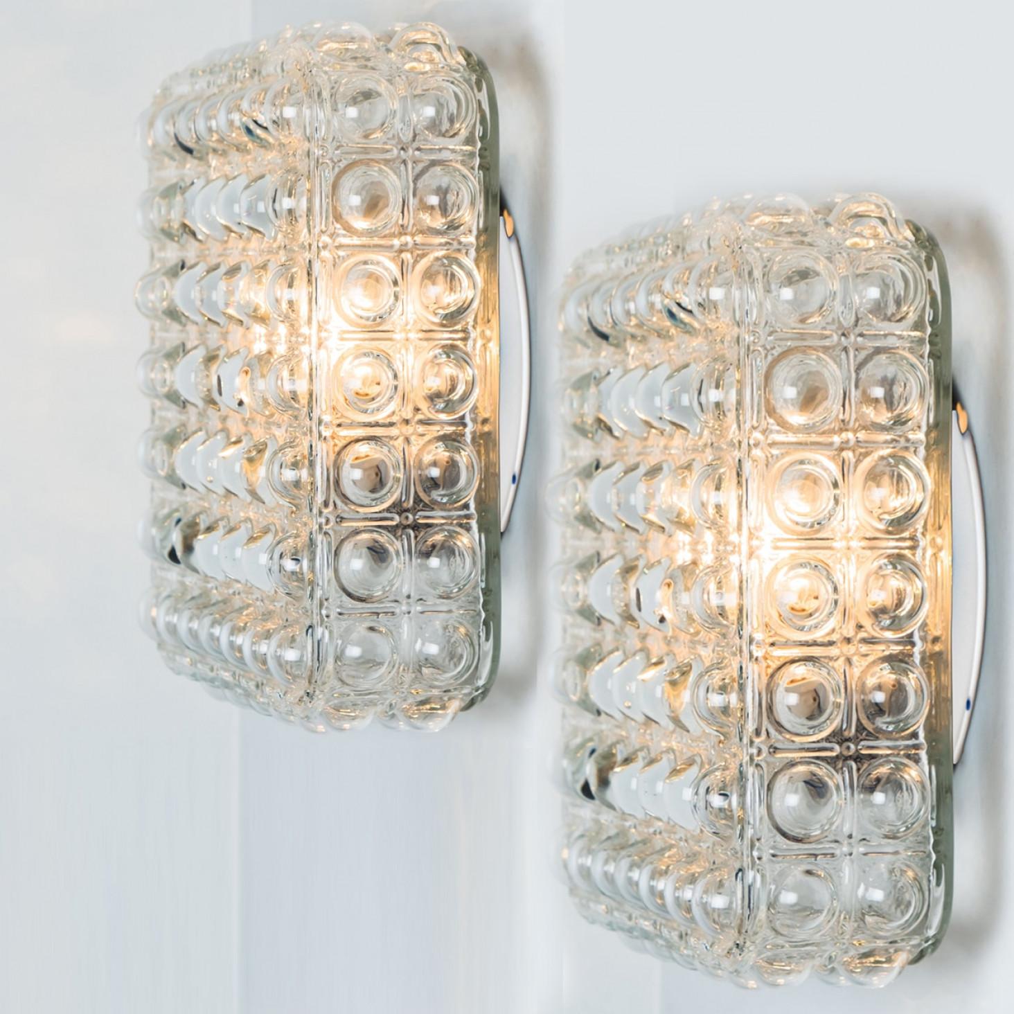 1 of the 2 beautiful bubble glass wall lights or flush mounts, designed by Helena Tynell, 1970. The rich textured glass gives a wonderful glow. The square glass is mounted on a silver colored metal back plate.

Cleaned, well-wired and ready to
