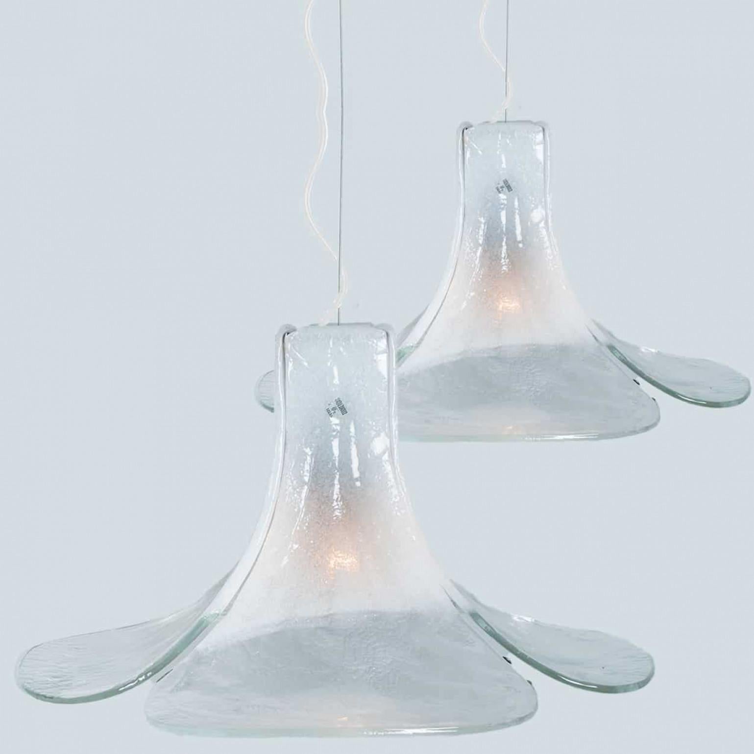 1 de las 2 lámparas colgantes con forma de flor fabricadas por Carlo Nason. Cuatro hojas cristalinas y blancas componen esta hermosa pieza realizada en grueso cristal de Murano hecho a mano.

Dimensiones:
Diámetro: 65 cm (25,59