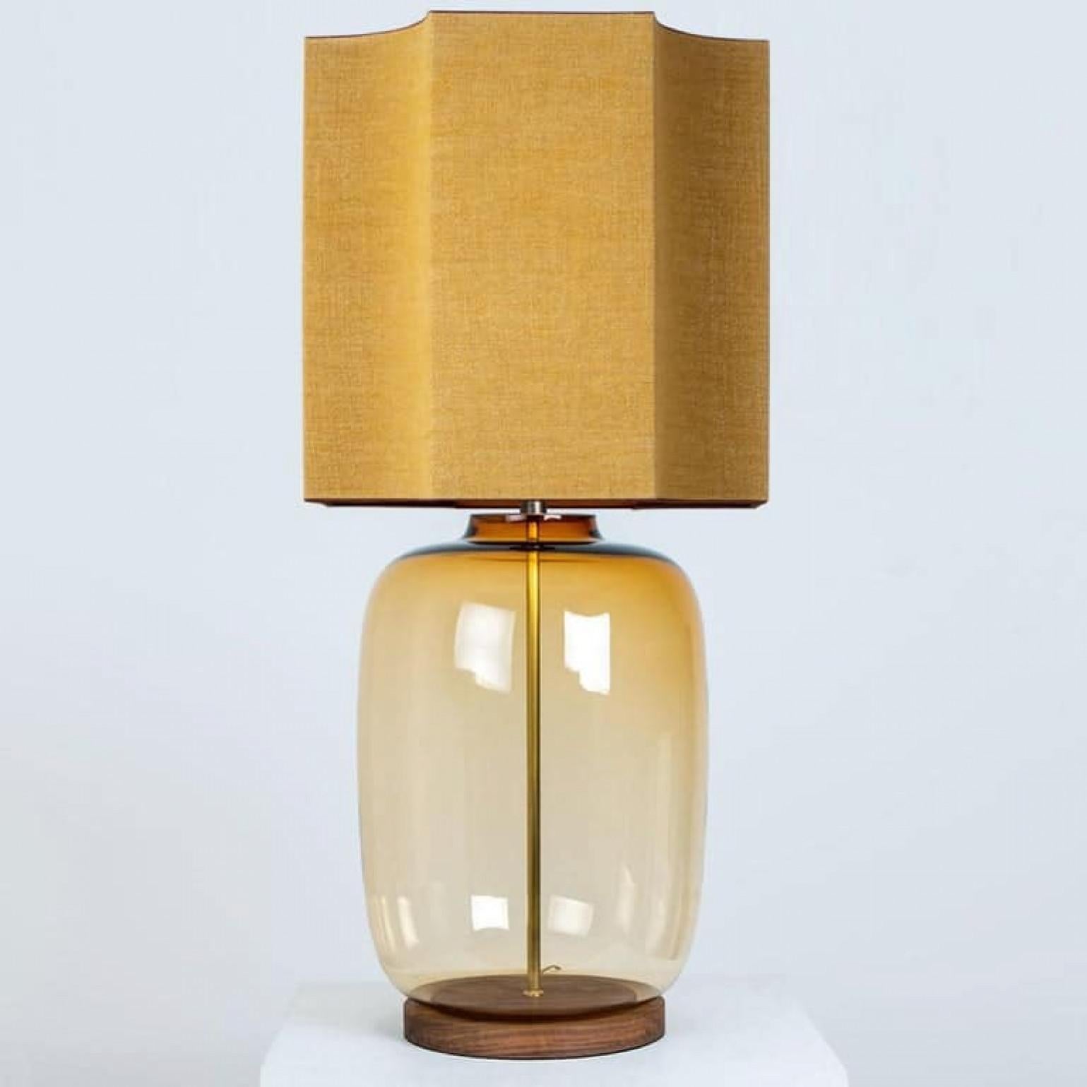 A unique Minimalist timeless design. Each extra large glass table lamp features a yellow exceptional transparent shaped base with a solid burr walnut foot with old brass accents and a brass rod running through the center. Enhancing the light and