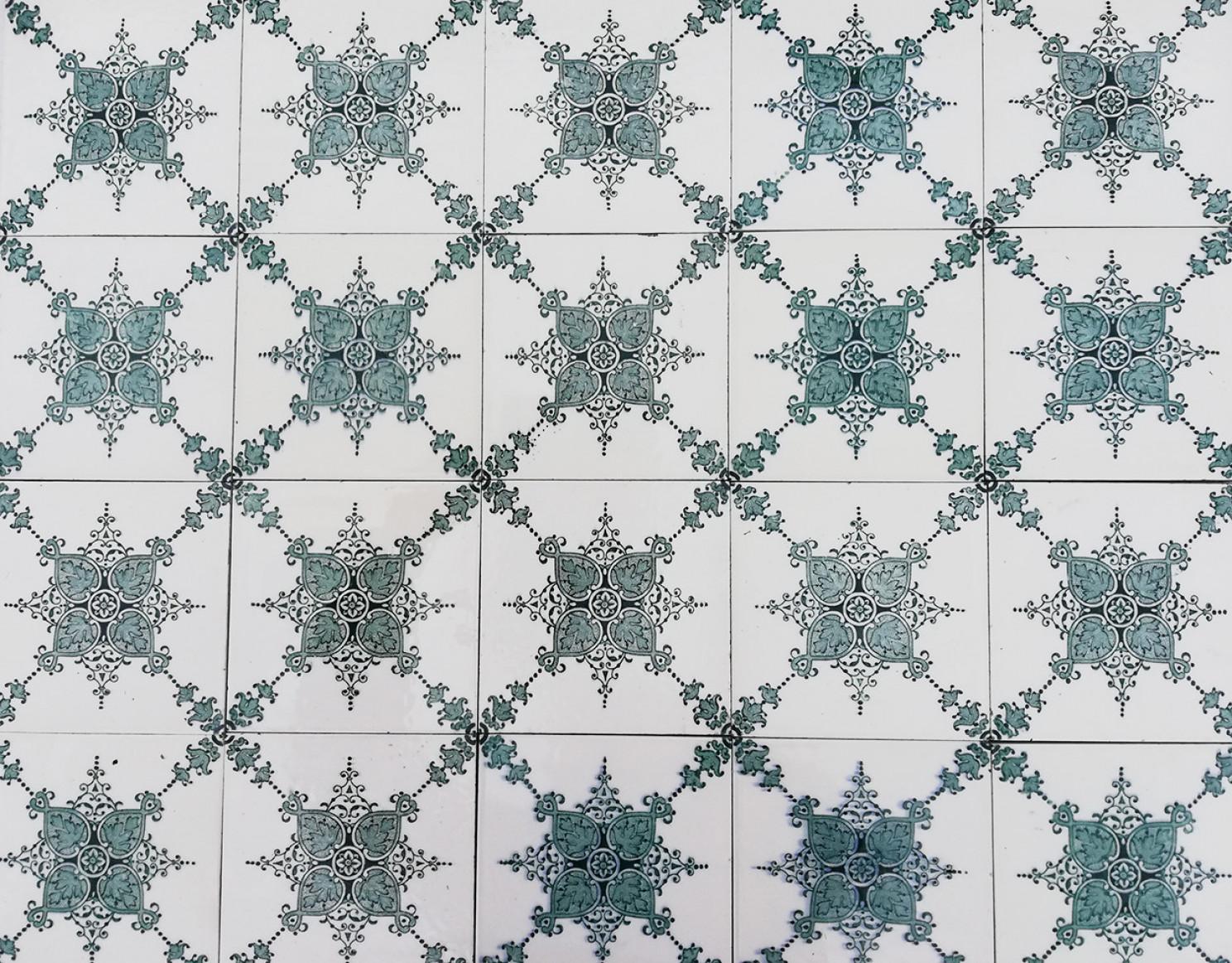 A large set of unique antique tiles, blue and dark green colored with a beautiful Art Deco pattern, Societe Morialme circa 1920, Belgium. On the tiles is in dark green and blue paint a beautiful, symmetrical floral design and pattern visible. These