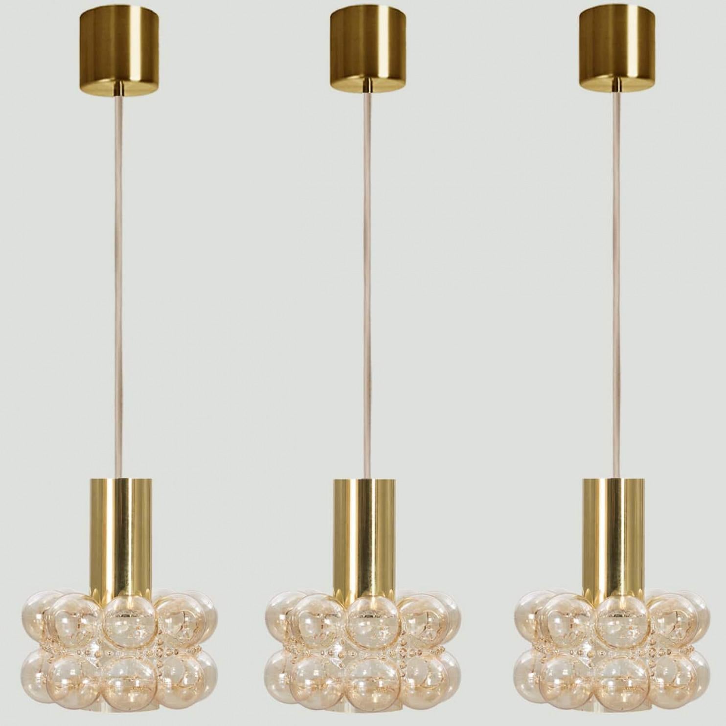 Several beautiful bubble glass pendant lights designed by Helena Tynell for Glashütte Limburg, 1960. A classig design with chrome colored details, the hand blown amber glass gives a wonderful glow.

Helena Tynell is a finish glass and ceramics