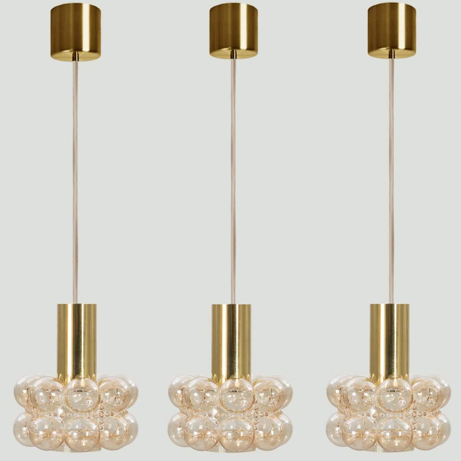 Several beautiful bubble glass pendant lights designed by Helena Tynell for Glashütte Limburg, 1960. A classig design with chrome colored details, the hand blown amber glass gives a wonderful glow.

Helena Tynell is a finish glass and ceramics
