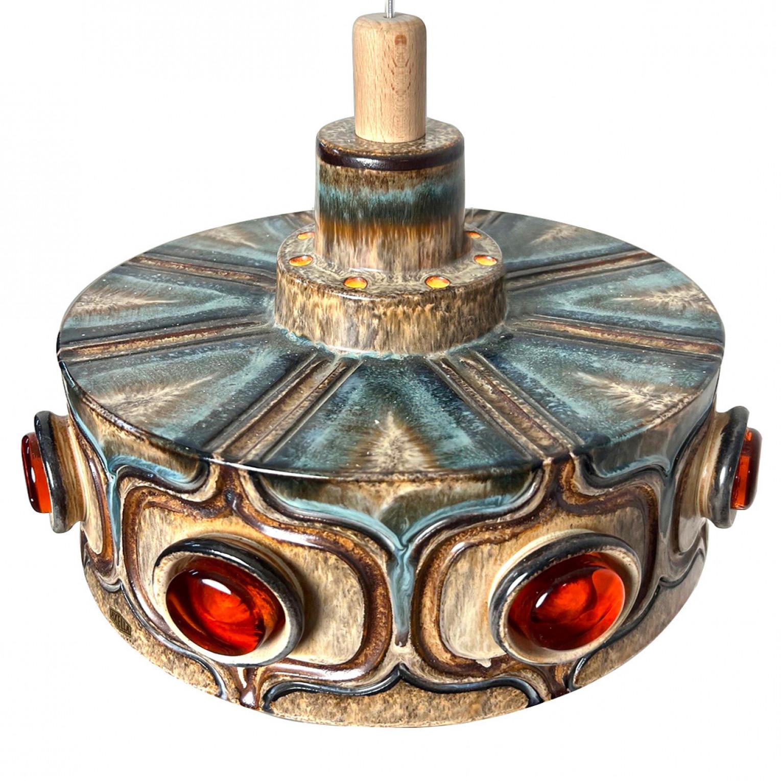 1 of the 3 stunning round hanging lamp with an unusual shape, made with rich colored blue,beige and brown ceramic, with terracotta/warm orange glass details, manufactured in the 1970s in Denmark.

With beautiful fragile steel cable and wooden