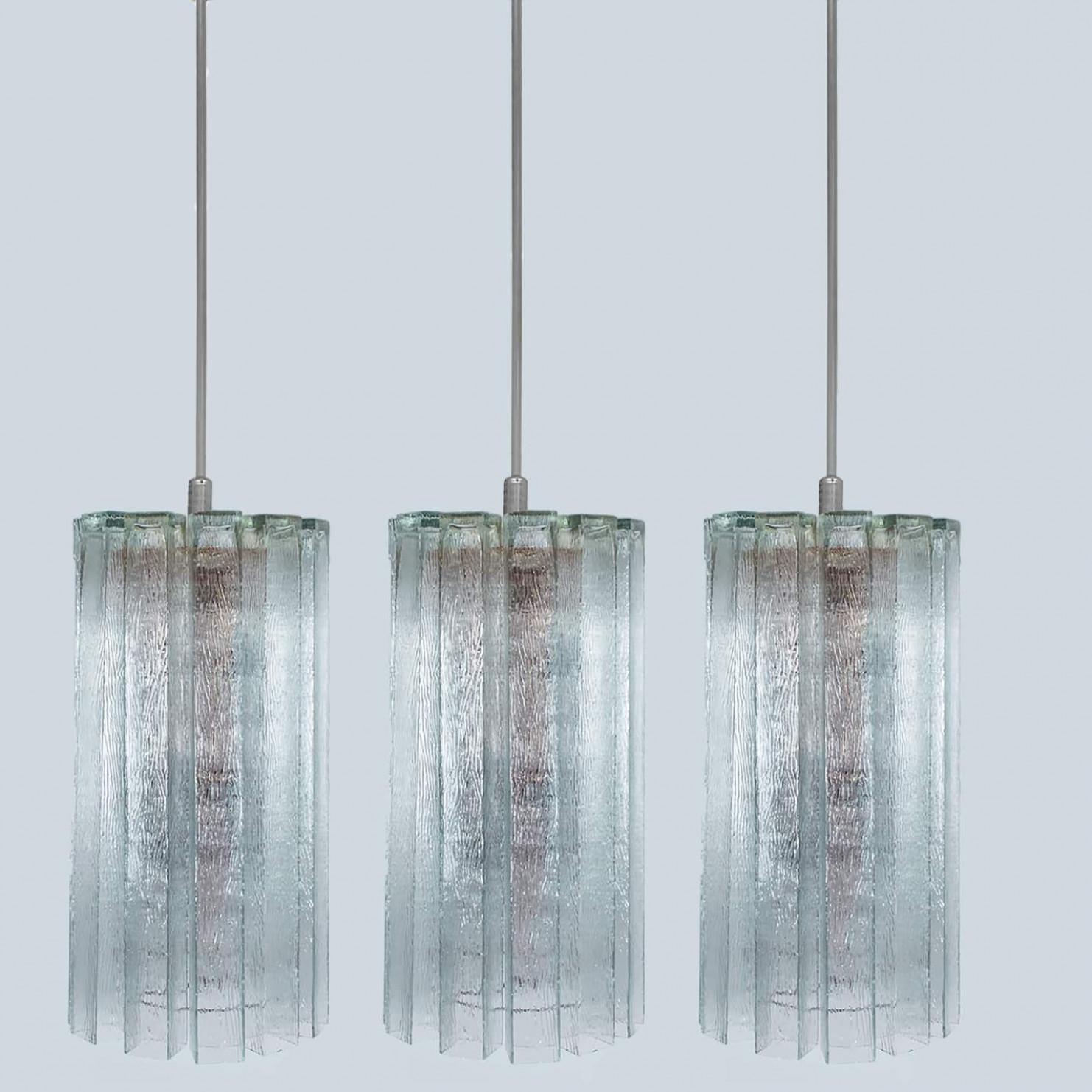 A Doria Leuchten glass chandelier, crafted in Germany during the 1970s, is truly captivating with its unique glass shapes. Twelve large cube-shaped hollow glass elements, featuring a ribbed pattern bring a unique ambiance to any room. The glass is