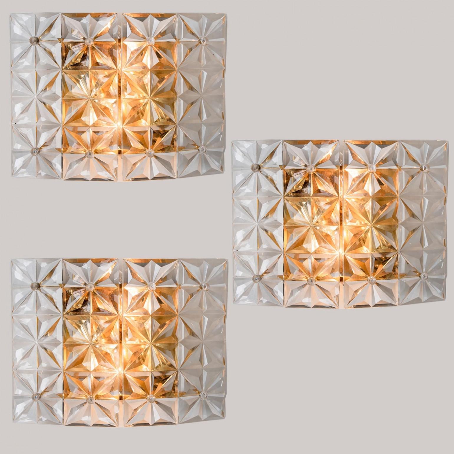 Lujosos apliques chapados en oro con cristal grueso del afamado fabricante Kinkeldey de Alemania, Europa. Fabricado en la década de 1970. Dos fuentes de luz. Luminarias muy elegantes, cómodas con todos los periodos de decoración. Los cristales están
