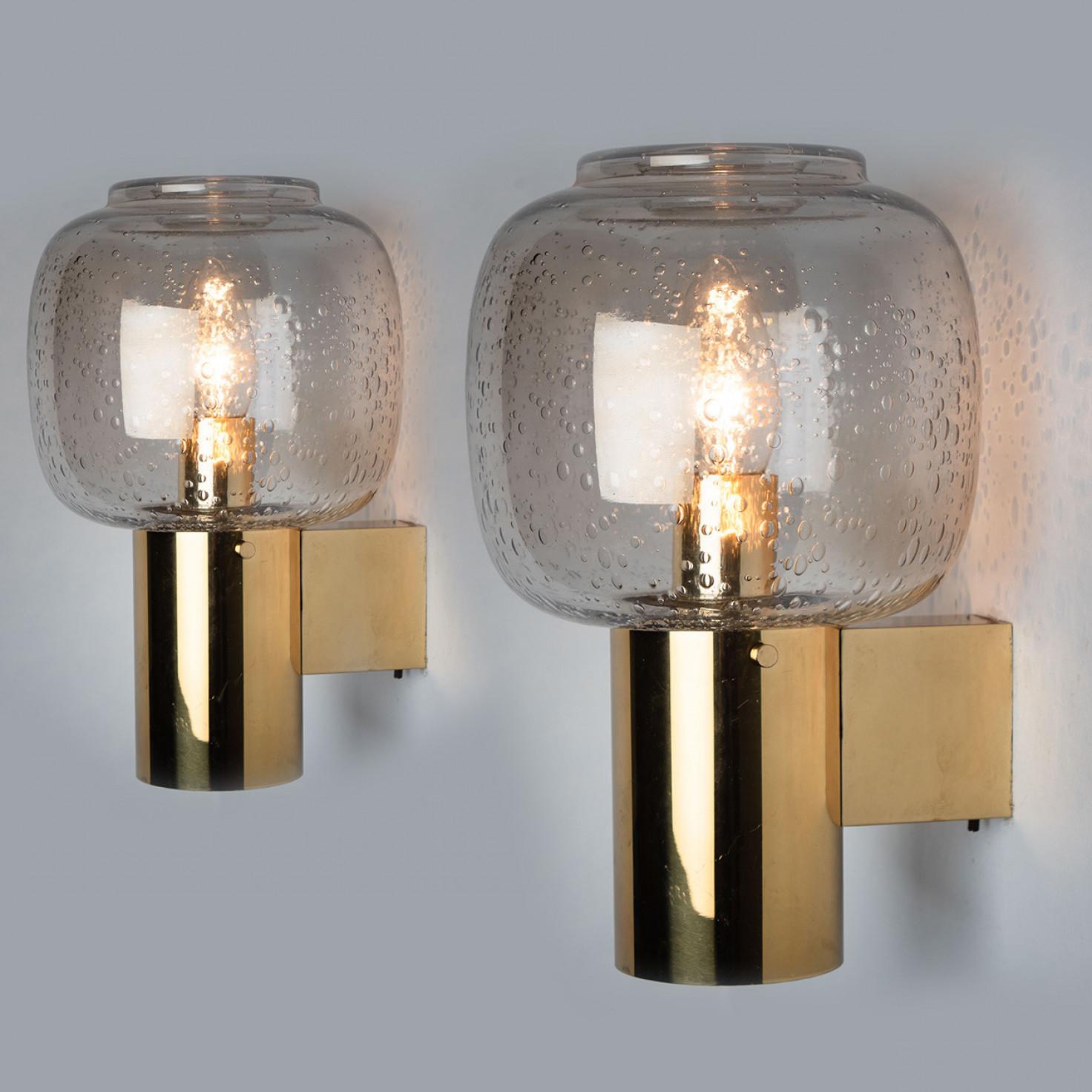 These stunning brass wall lights with clear bubbled glass are produced in the 1960s in the style of Hans-Agne Jakobsson. Design executed with a taste for excellence in craftsmanship.

Good cleaned respecting the beautiful patina, well-wired, in full