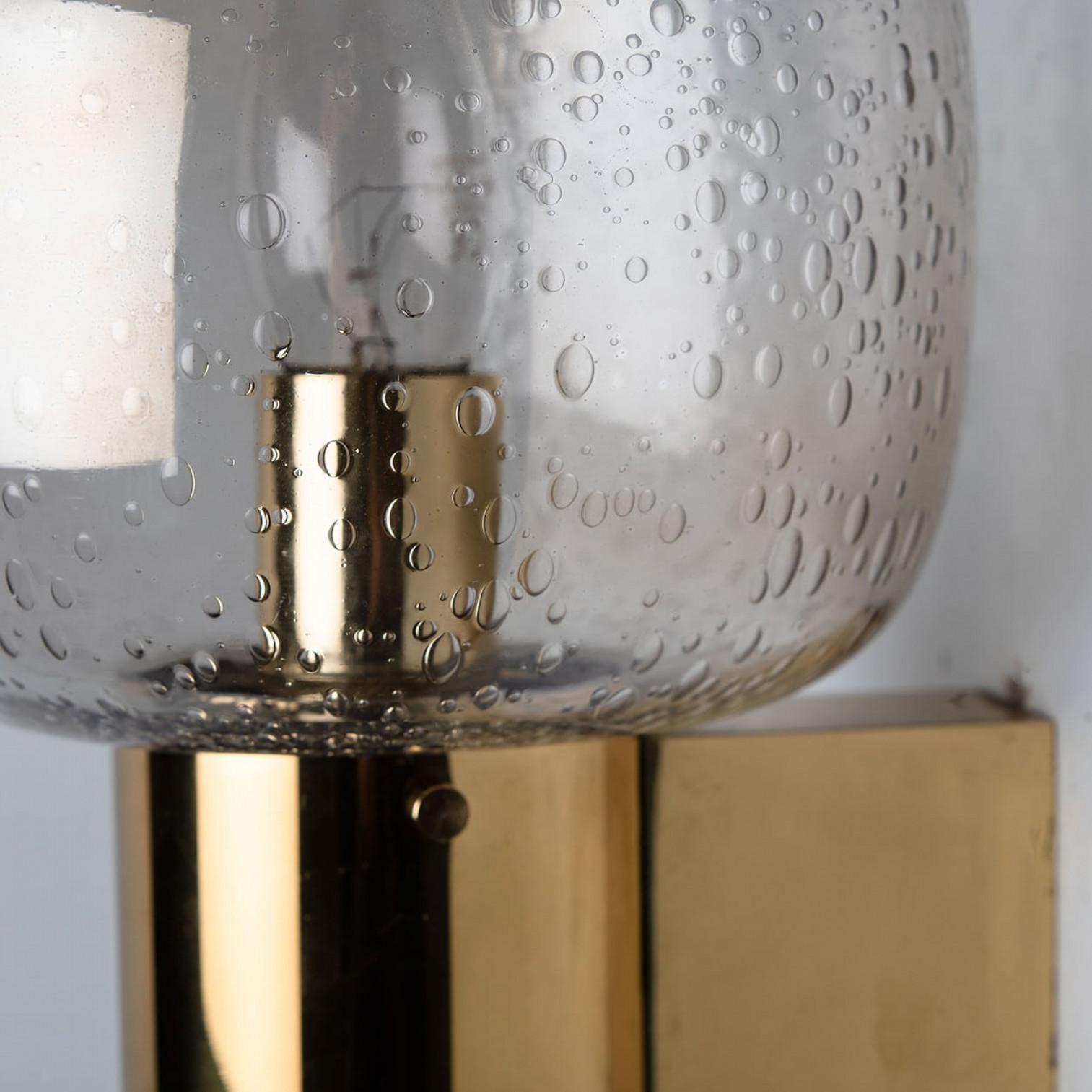 These stunning brass wall lights with clear bubbled glass are produced in the 1960s in the style of Hans-Agne Jakobsson. Design executed with a taste for excellence in craftsmanship.

Good cleaned respecting the beautiful patina, well-wired, in full