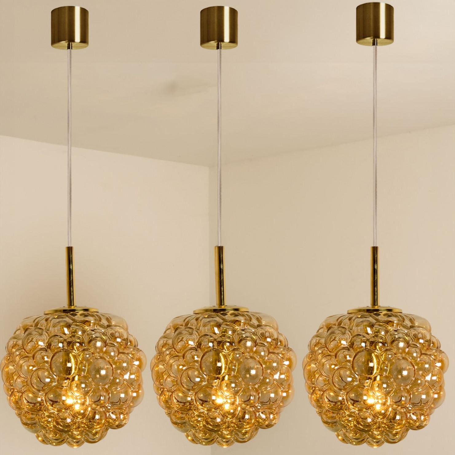 1 dei 3 bellissimi ciondoli con vetro a bolle d'aria di Helena Tynell, prodotti intorno agli anni Settanta.

Vetro ambrato soffiato a mano di alta gamma che crea un'illuminazione straordinaria in ogni ambiente.

Il cavo può essere regolato per