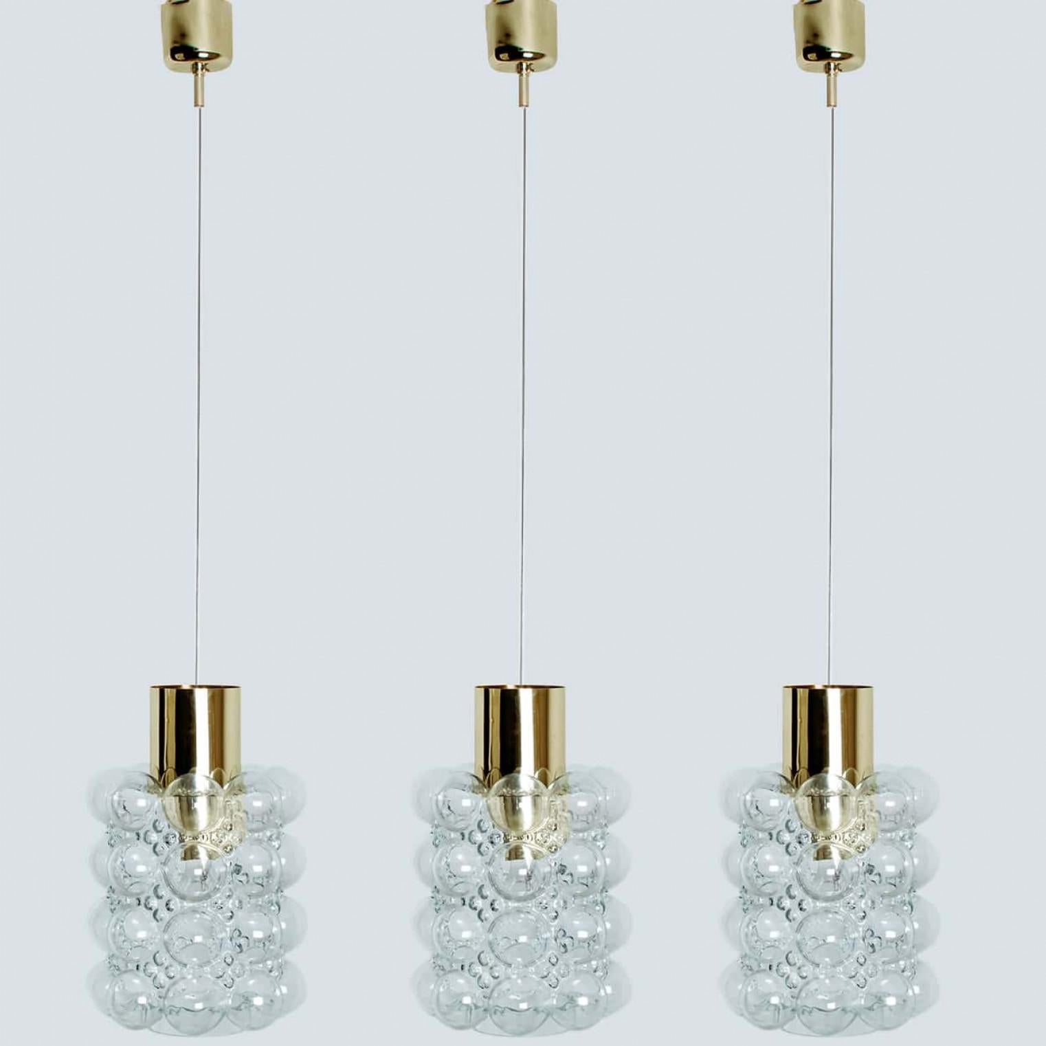 1 of the 3 beautiful bubble glass pendant lights designed by Helena Tynell for Glashütte Limburg, 1960. A classig design with brass colored details, the hand blown glass gives a wonderful glow.

Helena Tynell is a finish glass and ceramics designer.