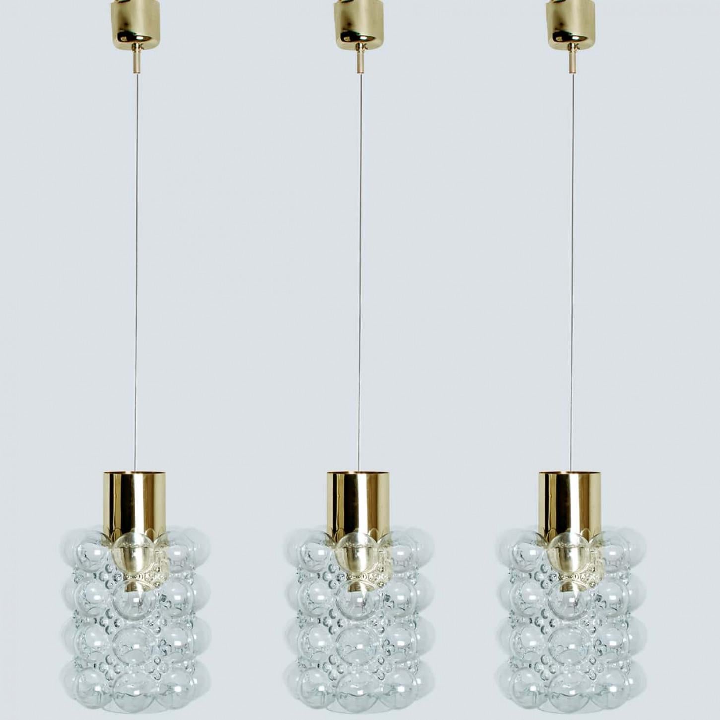 1 des 3 magnifiques lampes suspendues en verre bullé conçues par Helena Tynell pour Glashütte Limburg, 1960. Un design classique avec des détails en laiton, le verre soufflé à la main donne une merveilleuse lueur.

Helena Tynell est une créatrice de