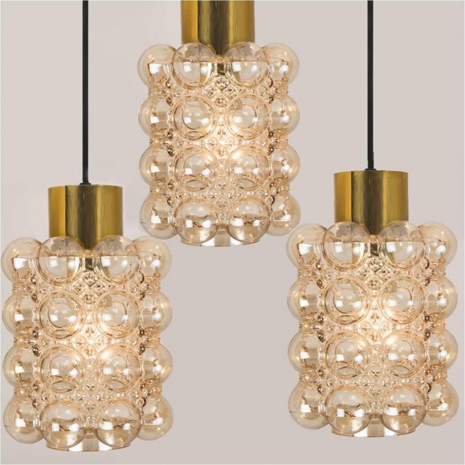 Three beautiful bubble glass chandeliers or pendant lights designed by Helena Tynell for Glashütte Limburg. A design Classic, the amber colored/toned hand blown glass gives a wonderful warm glow.

Please notice the price is for 1 piece. 3 pieces