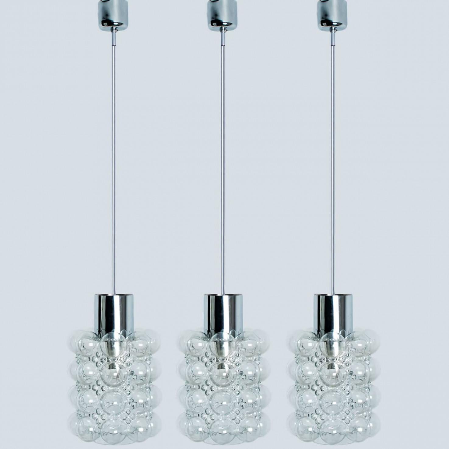 1 de las 3 preciosas lámparas colgantes de cristal burbuja diseñadas por Helena Tynell para Glashütte Limburg, 1960. Un diseño clásico con detalles cromados, el vidrio soplado a mano le da un brillo maravilloso.

Helena Tynell es diseñadora de