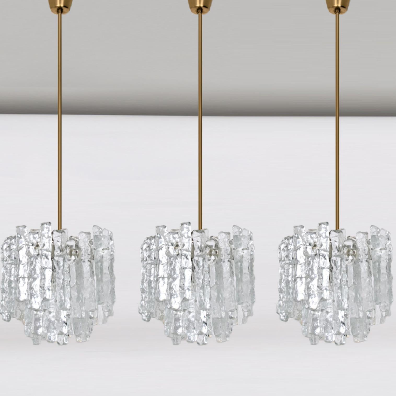 1 of the 3 beautiful and elegant modern chandeliers, manufactured by Kalmar Austria in the 1970s. Lovely design, each chandelier has 6 sockets and two layers of extremely stylish textured solid ice glass sheets (12 pieces) dangling on it.

Pleas