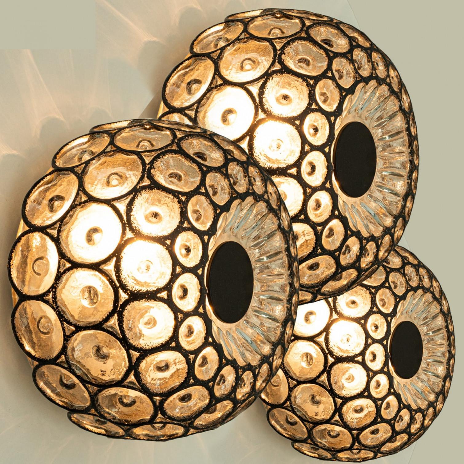 1 dei 3 grandi fuochi d'artificio in vetro della modernità di metà secolo di Limburg, 1960.

Anelli rotondi di ferro nero intarsiati in spesso vetro trasparente soffiato a mano su base metallica. Il design minimalista e geometrico proietta una luce