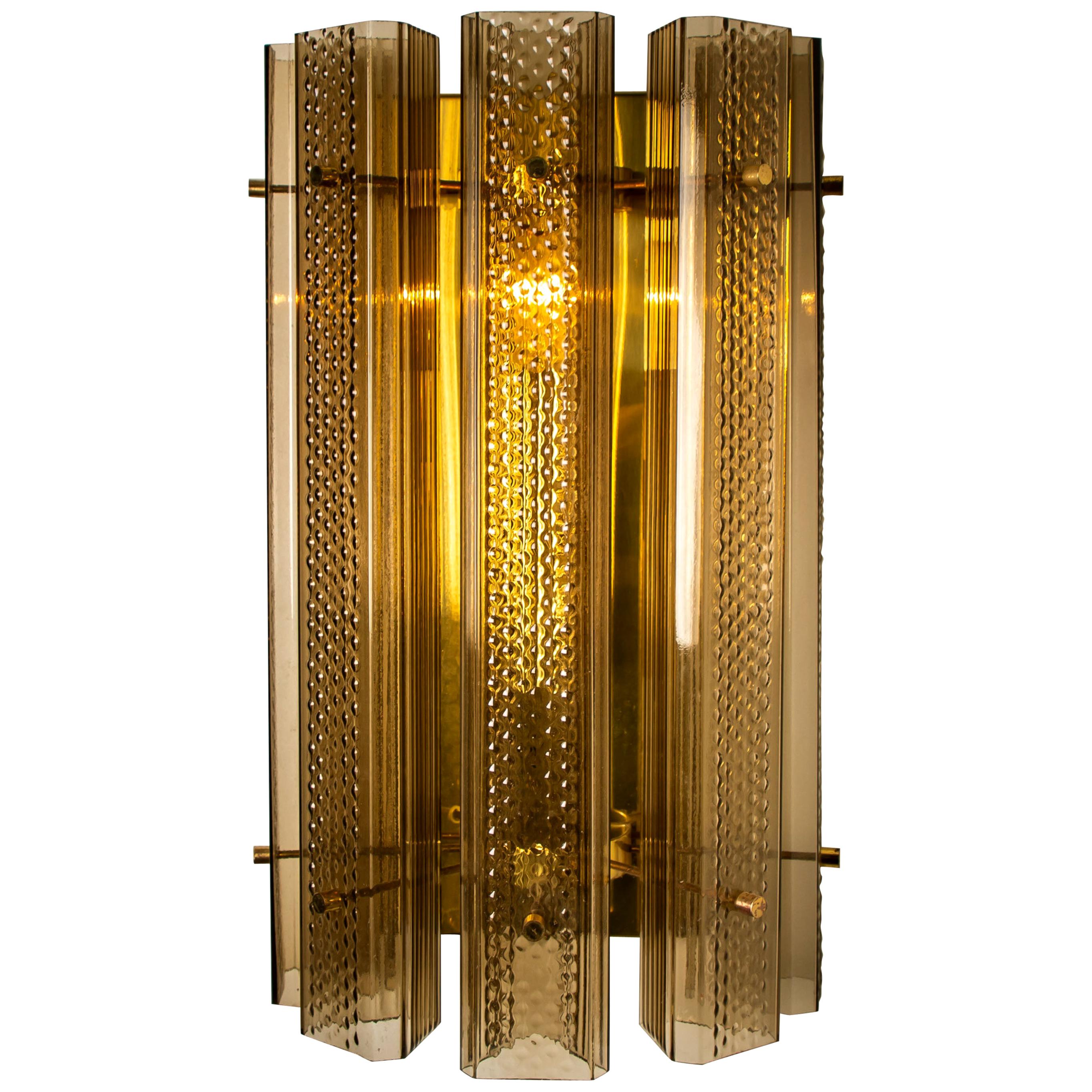 1 of the 3 pairs wonderful extra large Murano wall sconces, manufactured in the 1970s. The lights feature a brass frame with five large Murano square tubes in clear and smoked textured glass. With brass details. The tubes diffuse the light