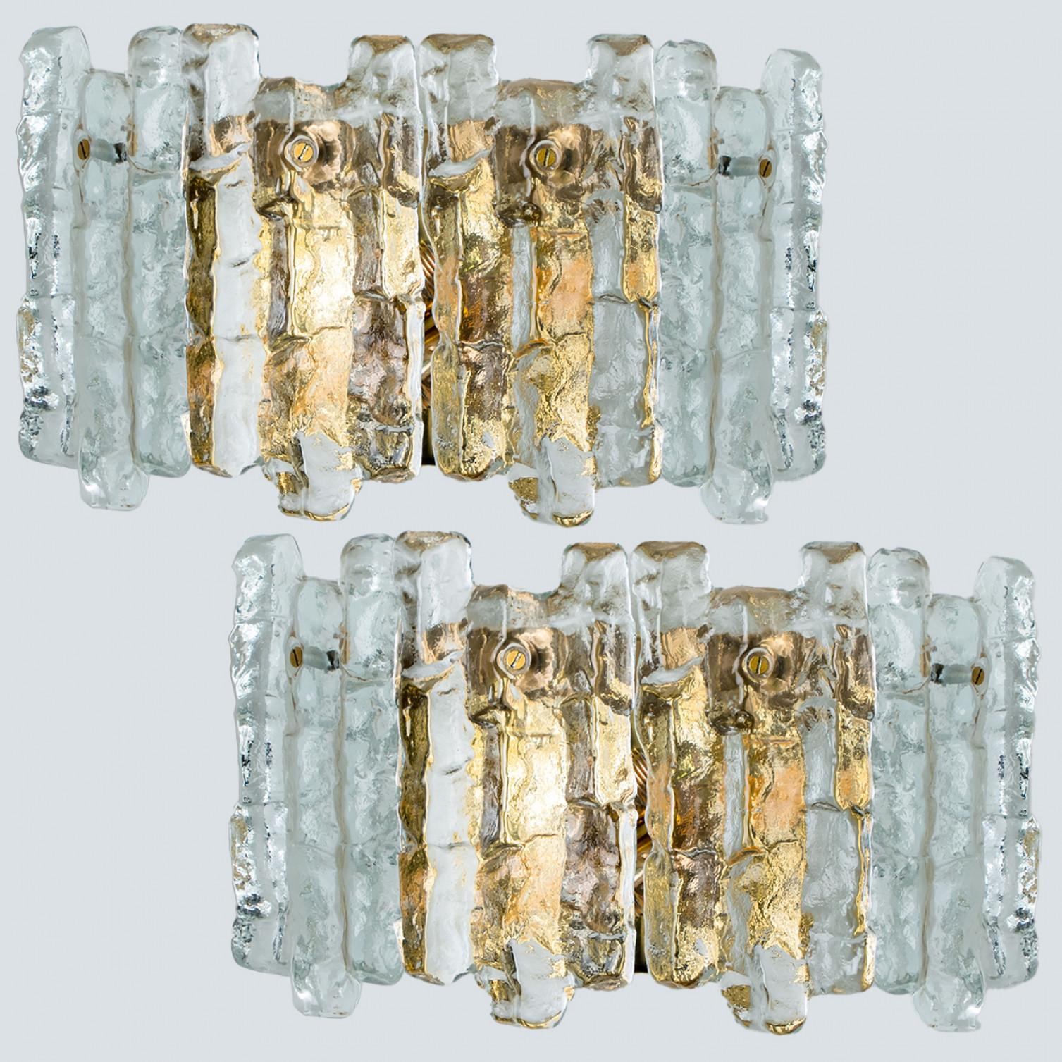 Pair of elegant modern high-end large brass wall lights or sconces, manufactured by J.T. Kalmar, Austria in the 1970s. Lovely design, executed to a very high standard. Each wall light has four solid ice glass sheets dangling on it. Clean lines to