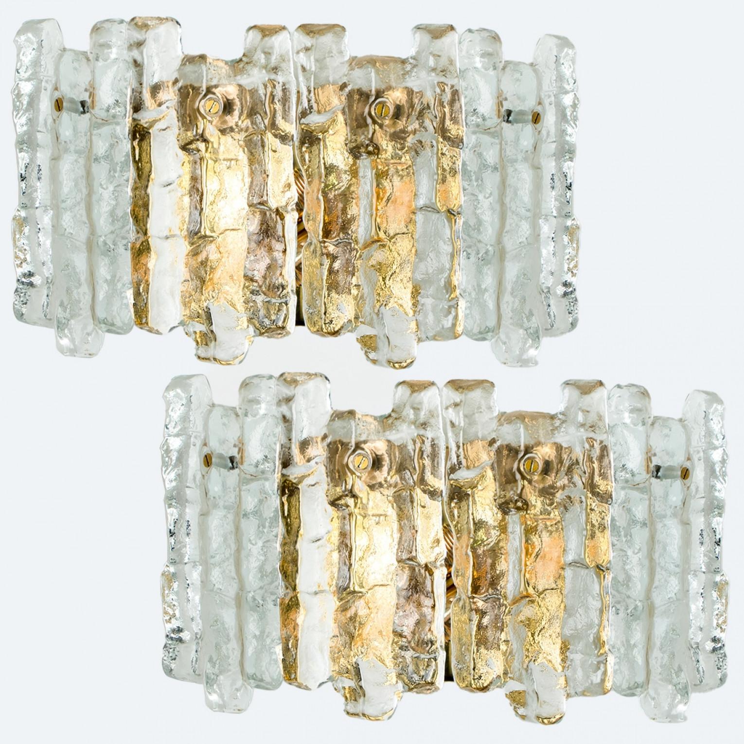 Pareja de apliques o candelabros grandes de latón, modernos y elegantes, fabricados por J.T. Kalmar, Austria, en la década de 1970. Un diseño encantador, ejecutado a un nivel muy alto. Cada aplique tiene cuatro láminas de cristal de hielo macizo