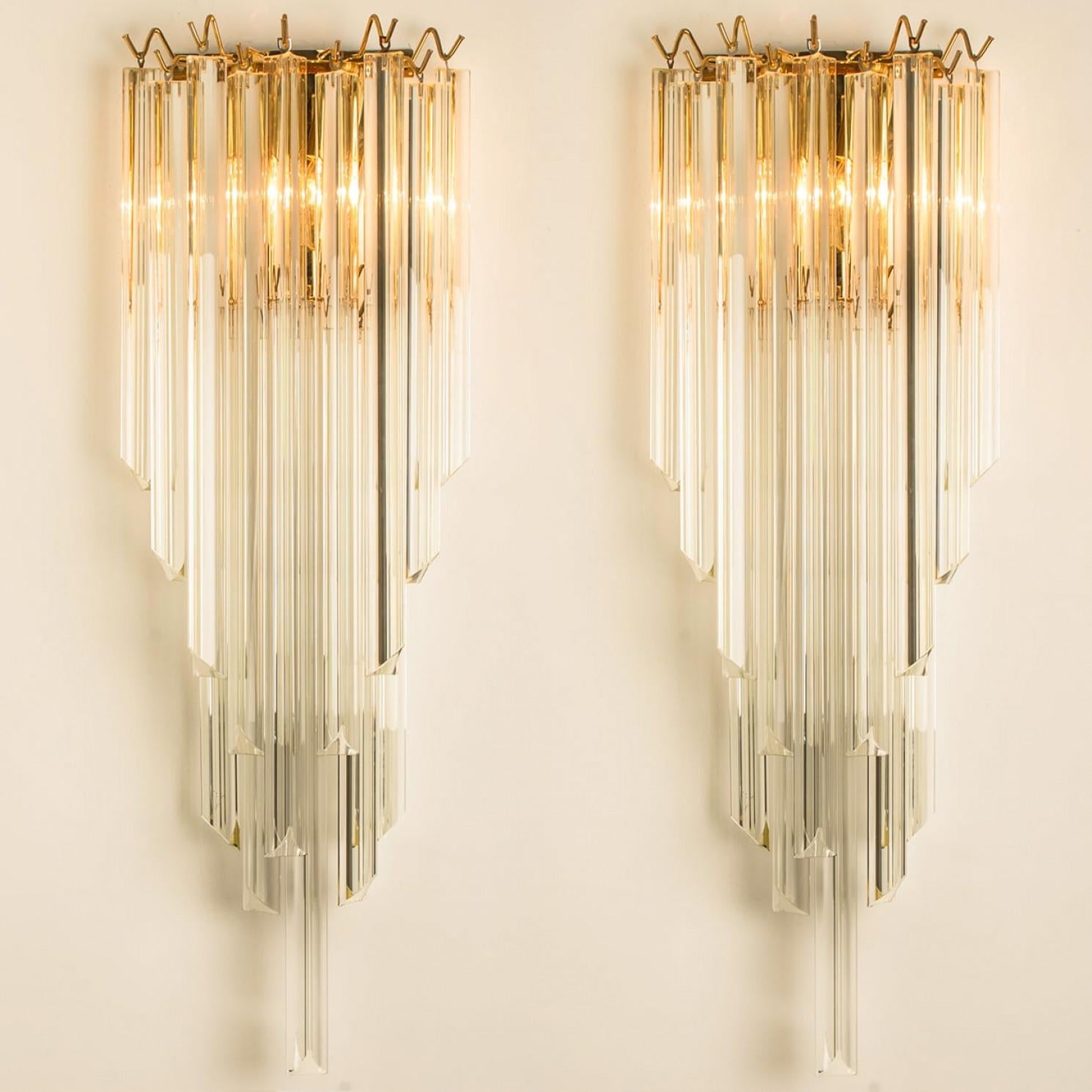 1 der 3 extra großen Murano-Glas-Wandleuchter-Paare mit fünf langen Prismenstäben aus kristallklarem Glas, mit vergoldeten Details und Rückwand. Leuchtet wunderschön.

Hochwertige Stücke, Statement-Stücke sind der Raum.

Gereinigt und gut verkabelt,