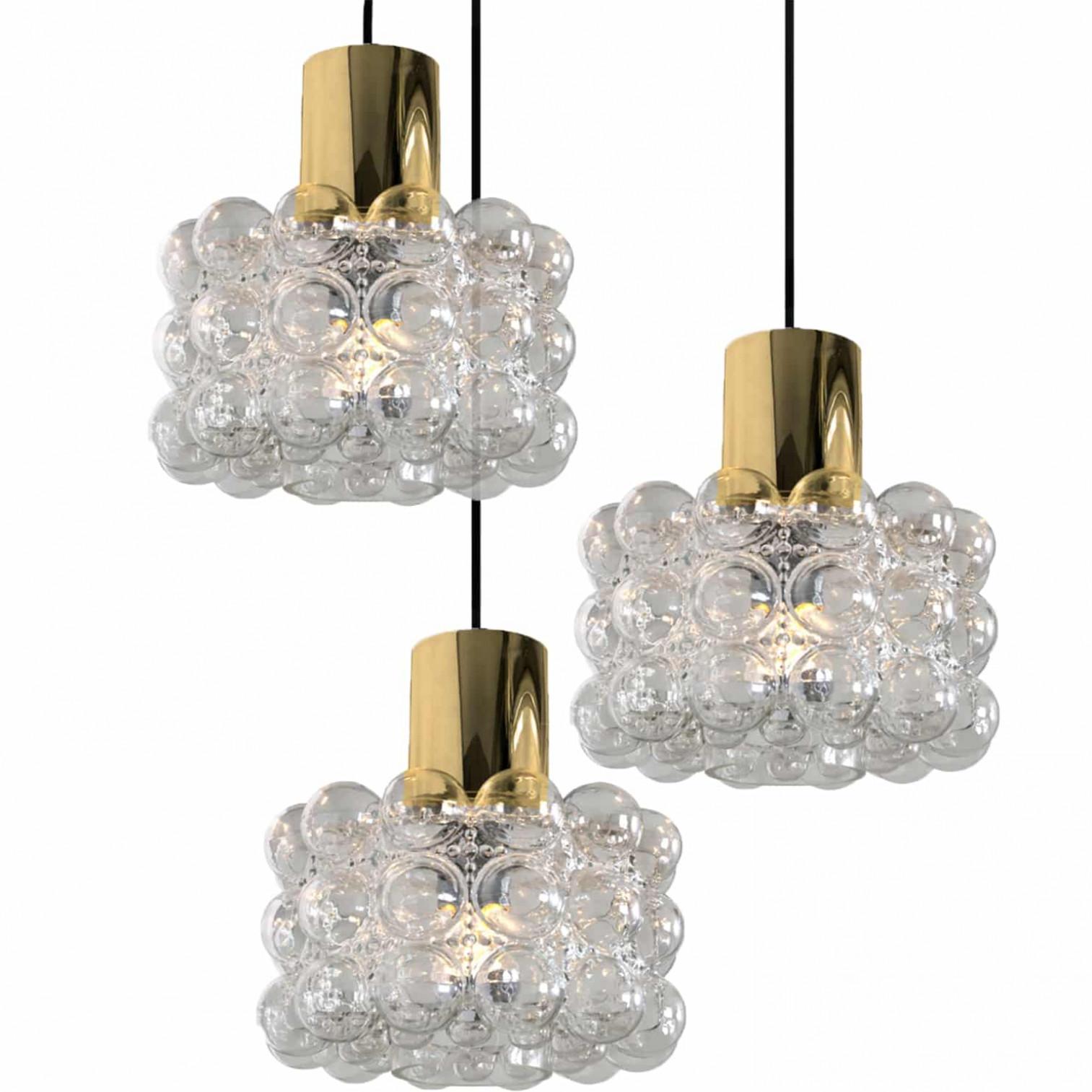1 de las 4 preciosas lámparas de araña o colgantes de cristal burbuja diseñadas por Helena Tynell para Glashütte Limburg. Un clásico del diseño, el vidrio soplado a mano proporciona un maravilloso resplandor cálido.

Las dimensiones: Altura 80 cm