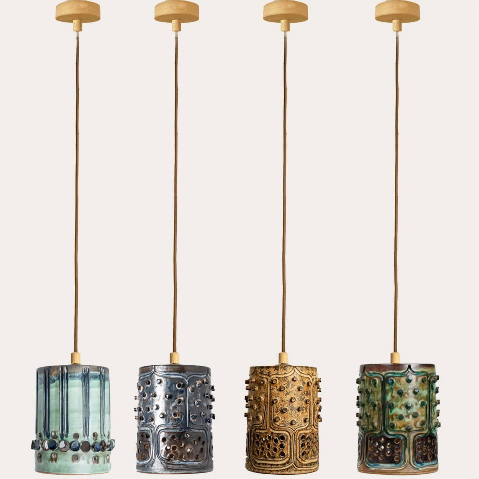 Impresionante juego de cuatro lámparas colgantes redondas de cerámica con un bonito dibujo, hechas con cerámica de ricos colores verde, azul y marrón, fabricadas por Jette Hellerøe para Axella en la década de 1960 en Dinamarca.

Axella fue fundada