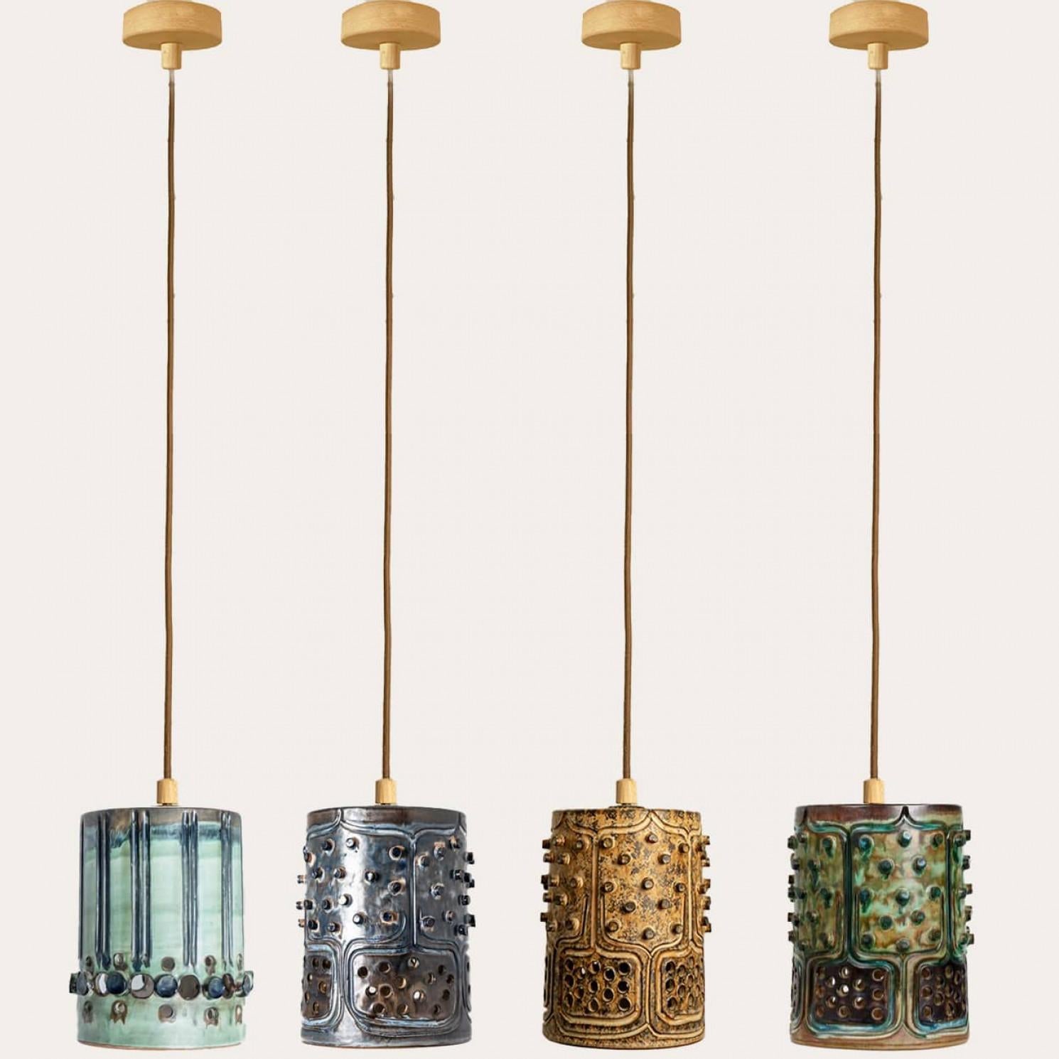 Impresionante juego de cuatro lámparas colgantes redondas de cerámica con un bonito dibujo, hechas con cerámica de ricos colores verde, azul y marrón, fabricadas por Jette Hellerøe para Axella en la década de 1960 en Dinamarca.

Axella fue fundada