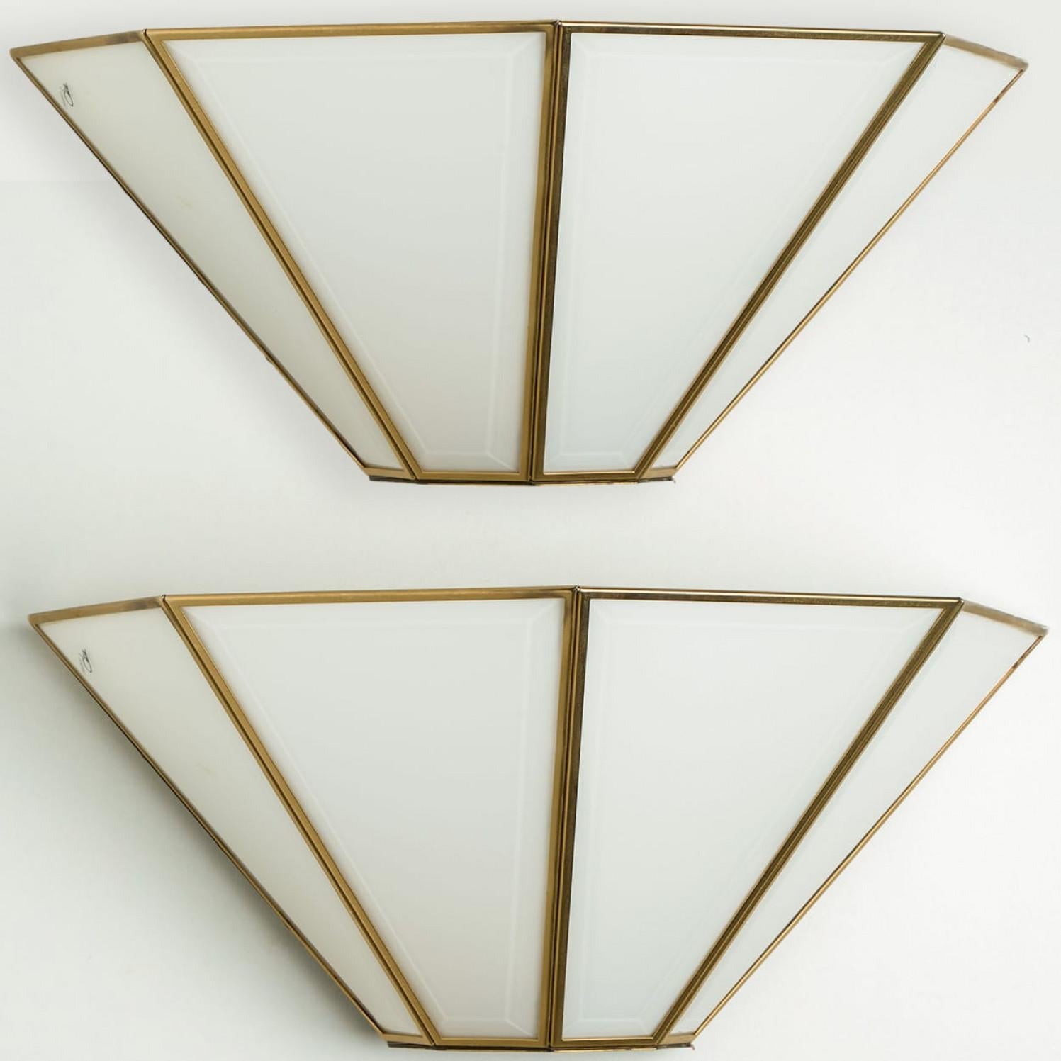 Un'applique moderna in vetro bianco di alta qualità proveniente dalla Germania, circa 1970.
Questa montatura da incasso è caratterizzata da più lastre di vetro soffiato a mano collegate da strisce dorate in un motivo a blocchi. Splendida