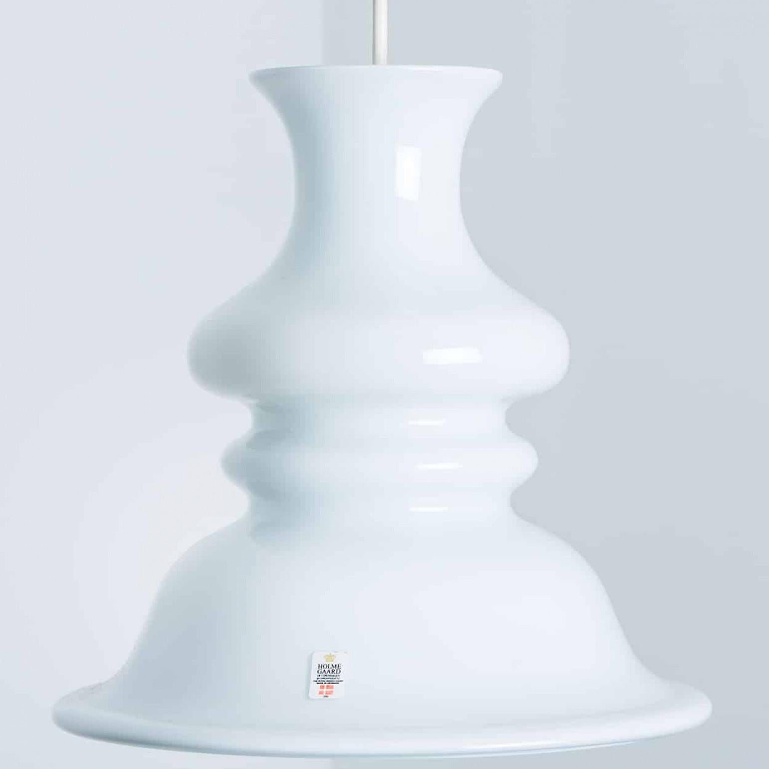 Questo set di bellissime lampade in vetro del marchio danese Holmegaard ha un bellissimo colore bianco. Il design è opera di Michael Bang, un designer il cui lavoro è oggi molto ricercato dai collezionisti del marchio. Un design pulito e di alto