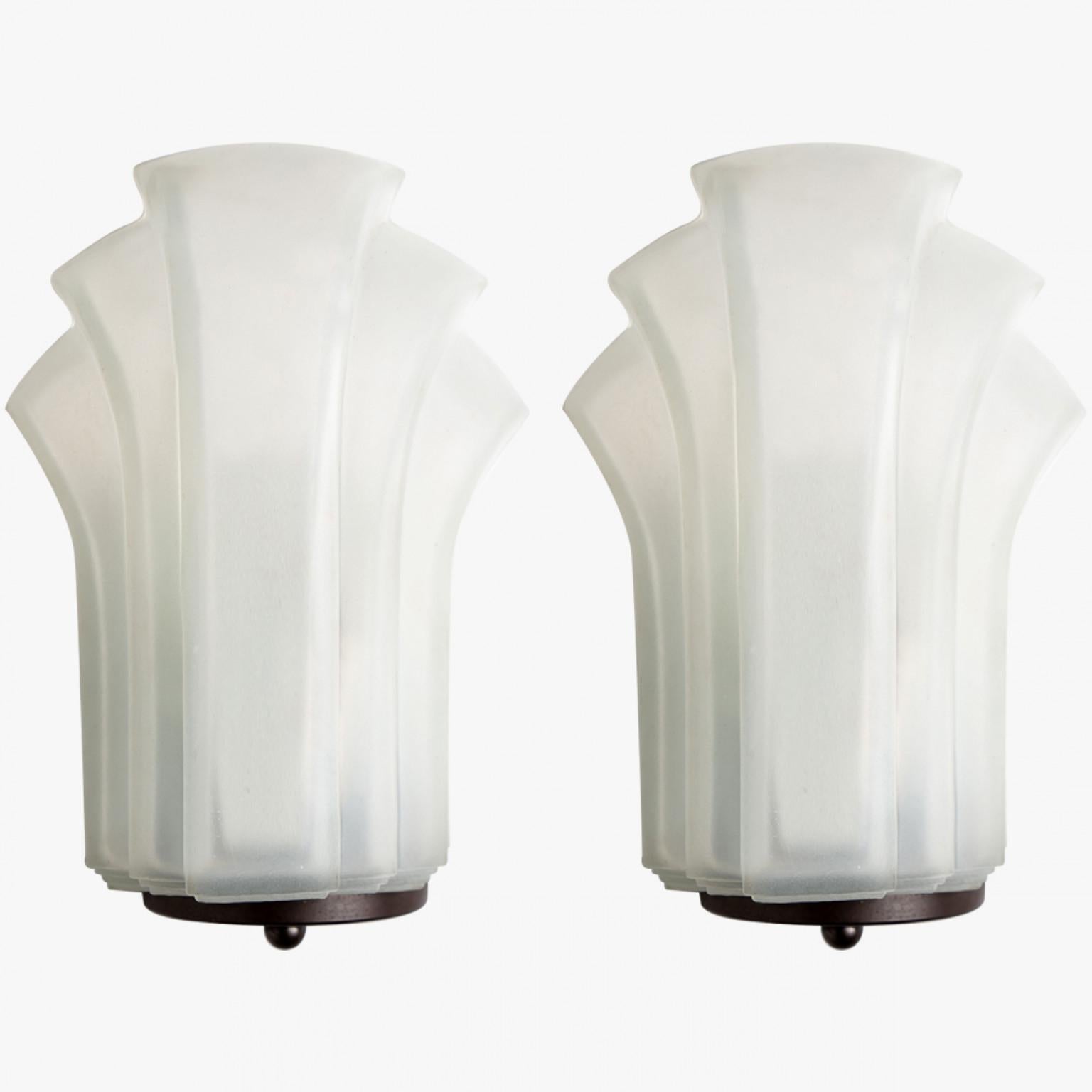 1 of the 4  Pairs Art Deco style milk glass wall lights. Manufactured in Germany around 1970.
The lights have the shape of a shell, in typical art deco lines. They would be a winning addition to any style of interior from Danish modern to Space Age