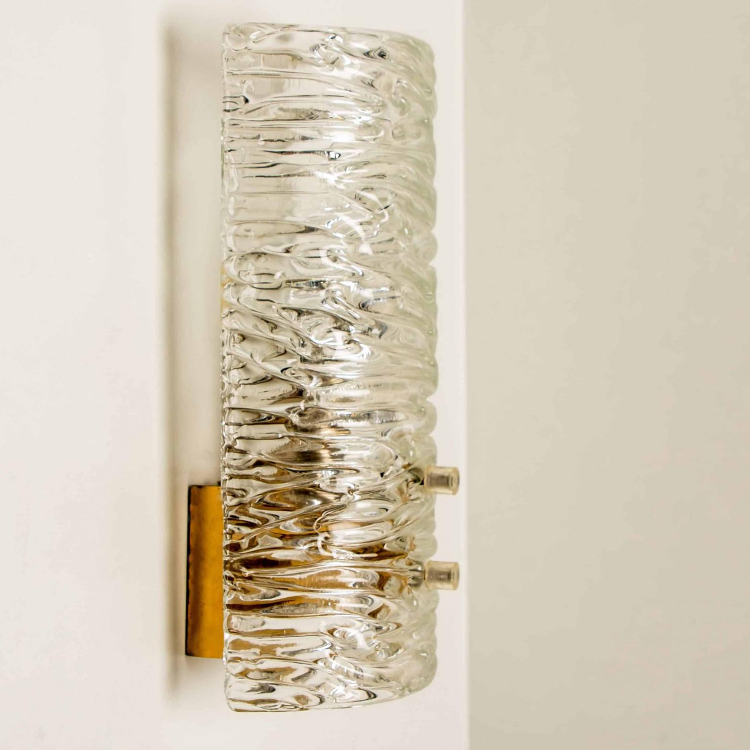 Große Anzahl von Wandleuchten von J.T. Kalmar, Wien, Österreich, hergestellt ca. 1960. Die Wandleuchten sind handgefertigt und hochwertig. Jede Wandleuchte hat einen halbrunden, wellenförmigen, strukturierten Glasschirm mit einer