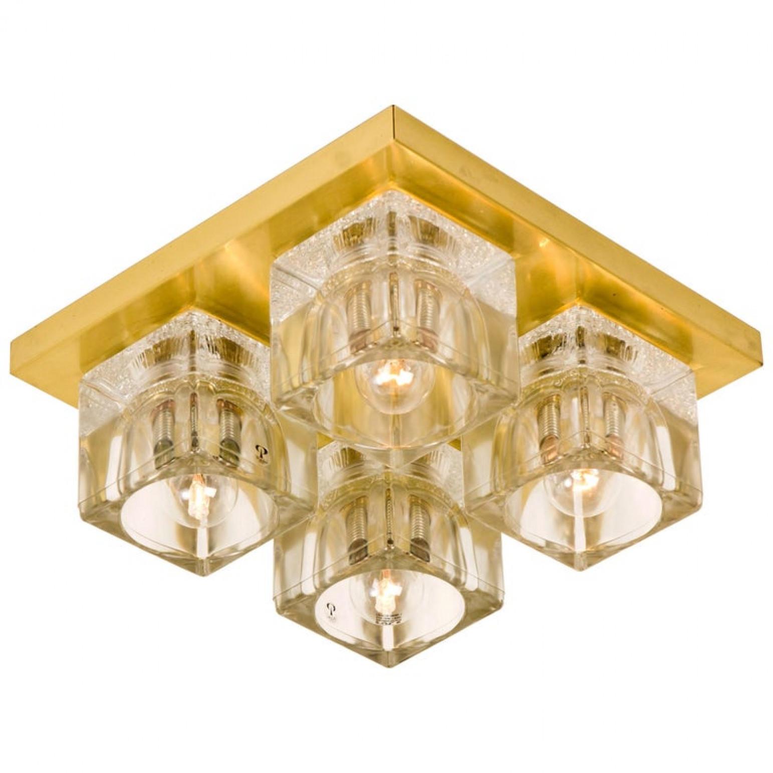 Cette sculpturale applique murale vintage se compose de quatre cubes en verre clair sur un cadre carré en laiton qui reflète magnifiquement la lumière avec une lueur chaleureuse. Les quatre abat-jours cubiques en verre clair épais de qualité ont un