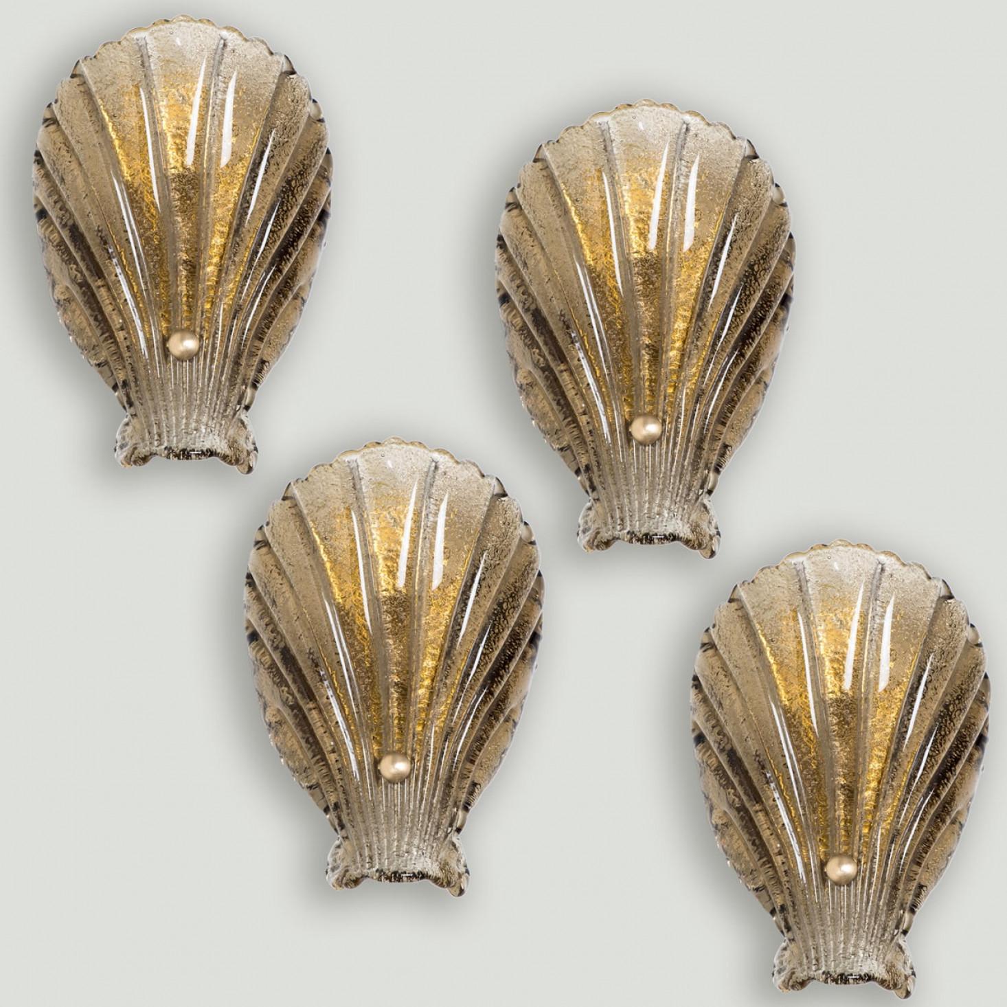 1 of the 4 Elegant hand-blown Murano glass wall light in the style of  Barovier & Toso, Italy. Manufactured late 1960s, early 1970s.
The light fixture consists of a blown Murano glass shell, a wide cover, mounted on a brass frame. The glass is