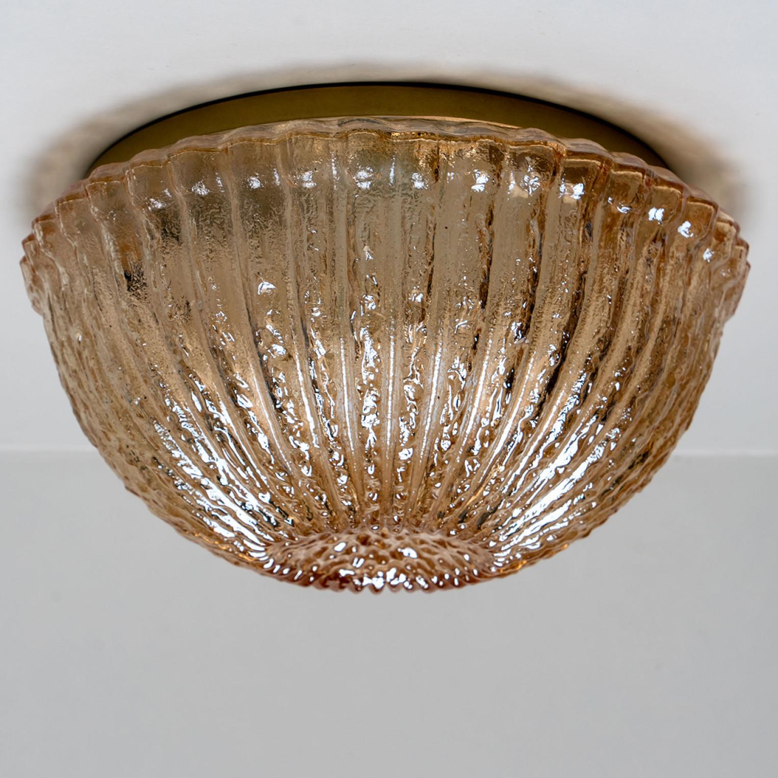 Mid-century flush mounts, wall lights or sconces by Peill & Putzler in the 1970s.
Featuring a smoked glass globe shade with a waved/ribbed glass. Casting a stunning light across a wall or ceiling. The brass fixture and smoked glass looks stunning in