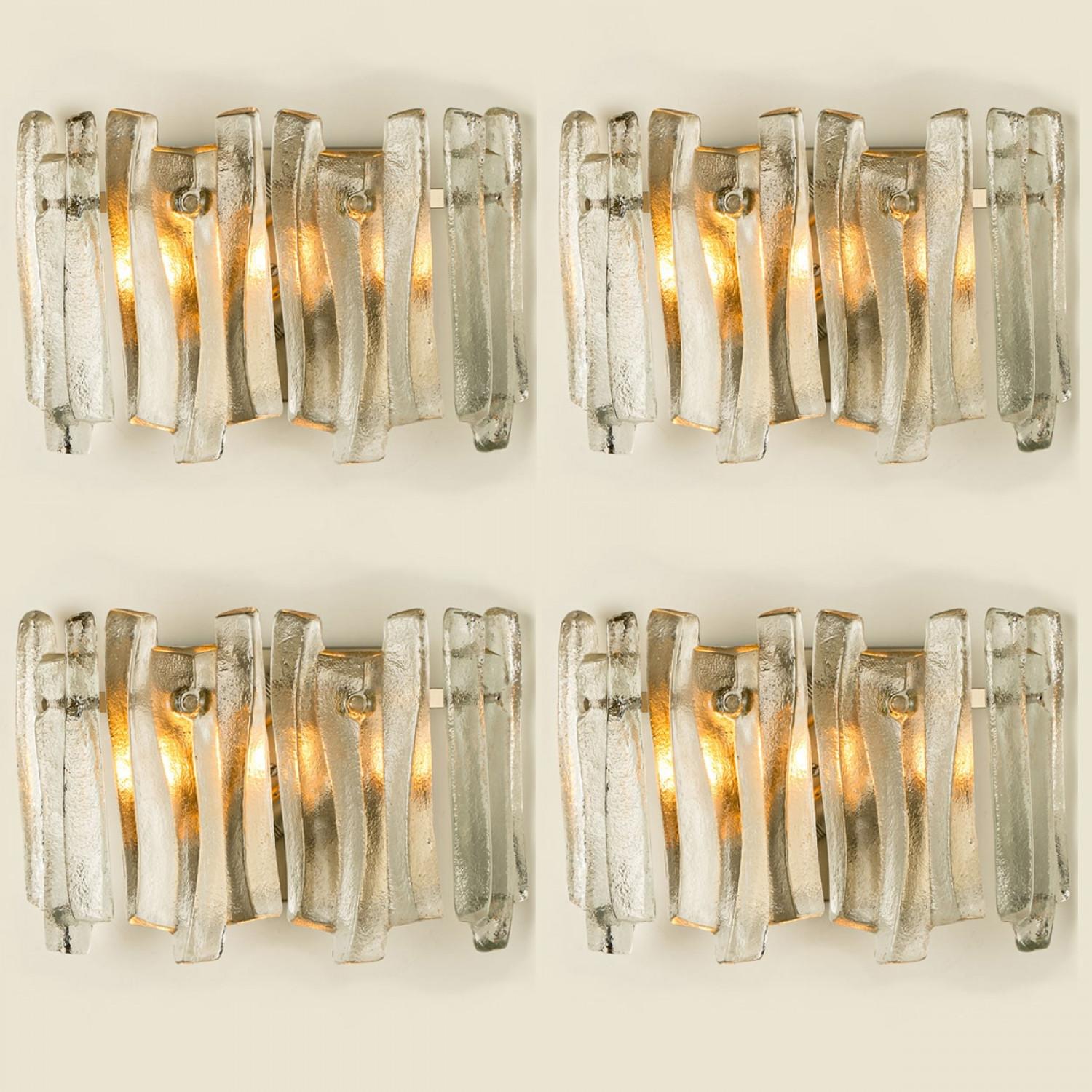 Preciosos y elegantes apliques modernos al estilo de Kalmar en la década de 1970. Un diseño precioso. Doce gruesas vigas de cristal texturizado en forma de onda orgánica. El cristal transparente tiene un aspecto helado y artesanal, creando un efecto