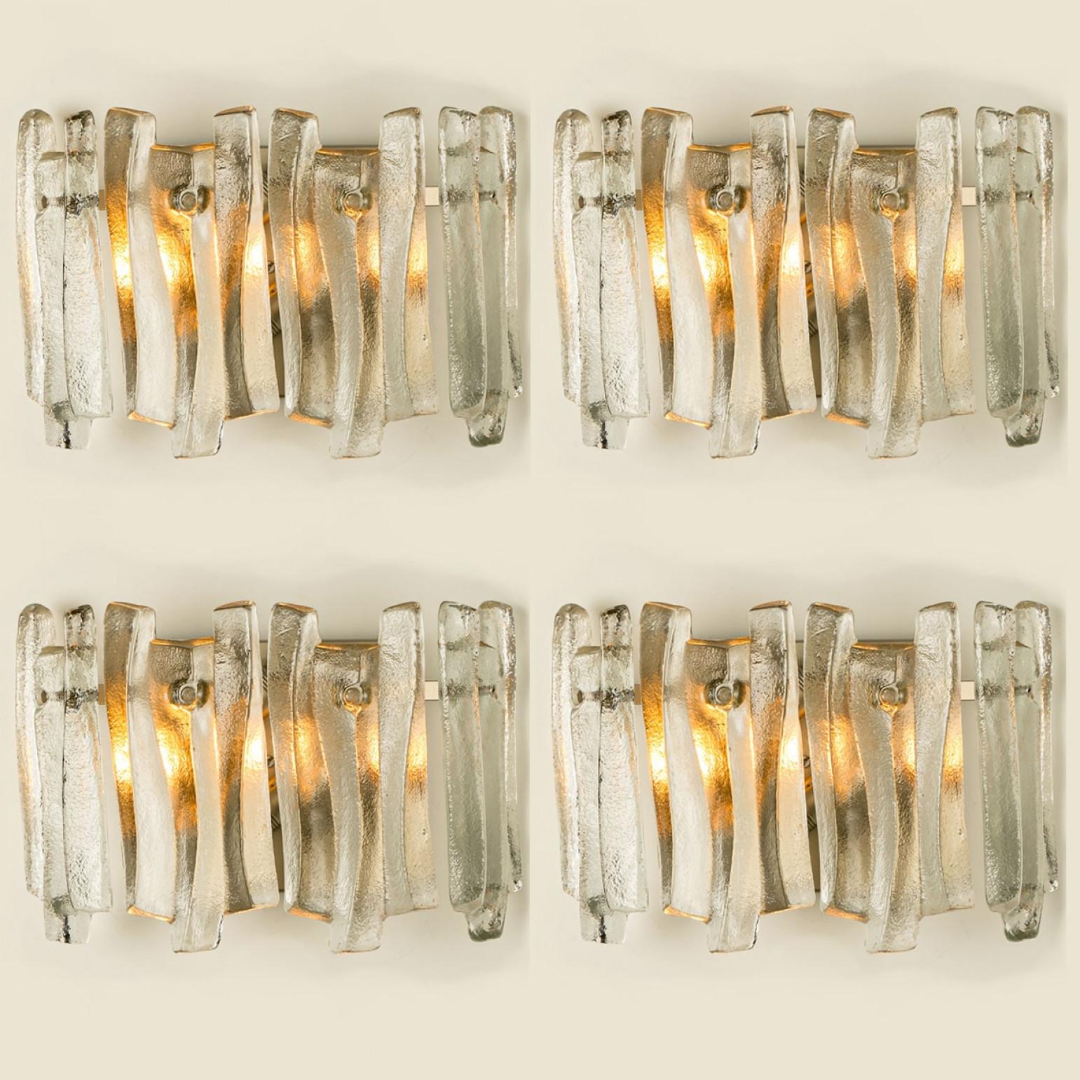 Preciosos y elegantes apliques modernos al estilo de Kalmar en la década de 1970. Un diseño precioso. Doce gruesas vigas de cristal texturizado en forma de onda orgánica. El cristal transparente tiene un aspecto helado y artesanal, creando un efecto