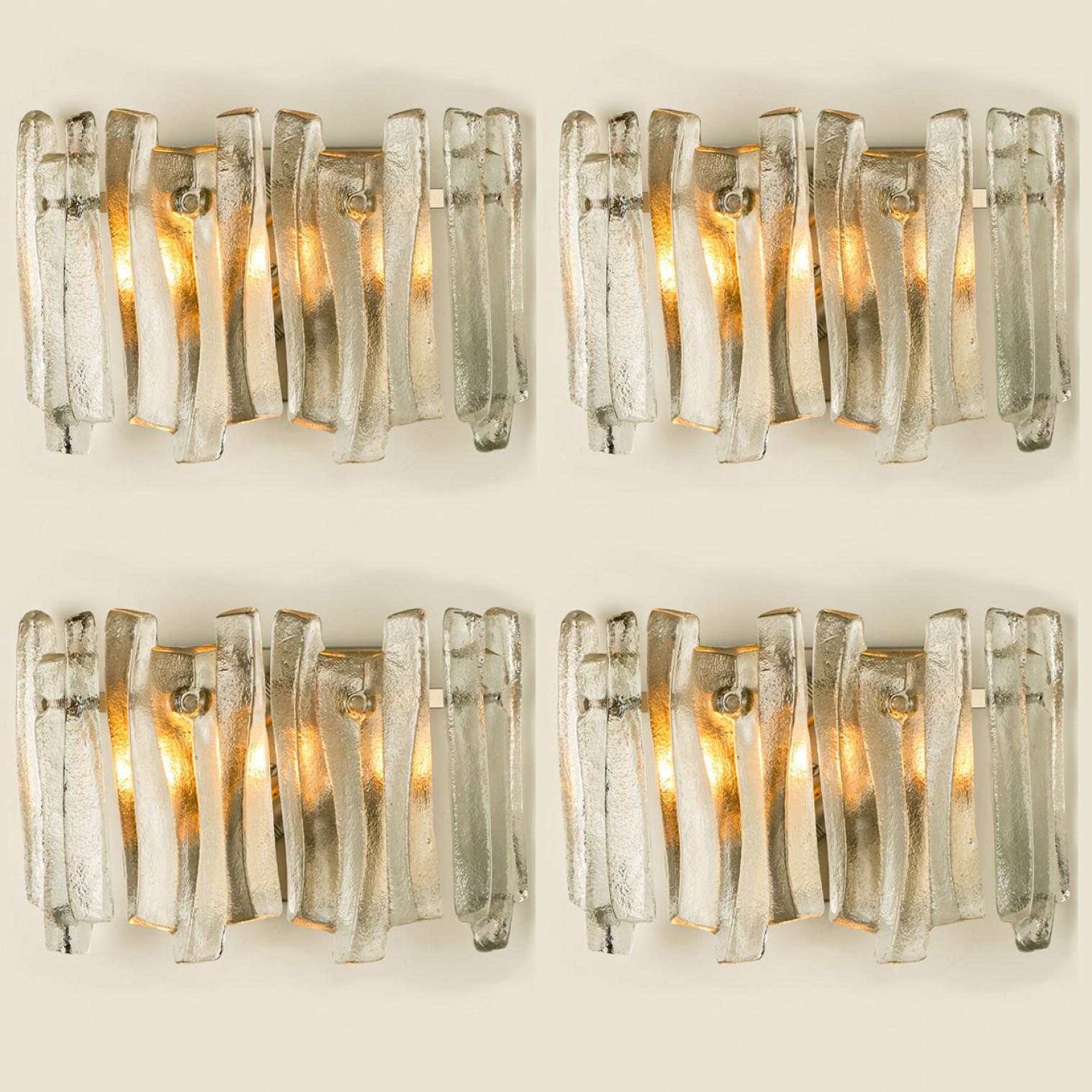 Beautiful and elegant modern wall lights in the style of Kalmar in the 1970s. A lovely design. Twelve thick, textured glass beams in an organic, wave-like shape. The clear glass has an icy, handcrafted look, creating a sculptural and elegant effect.