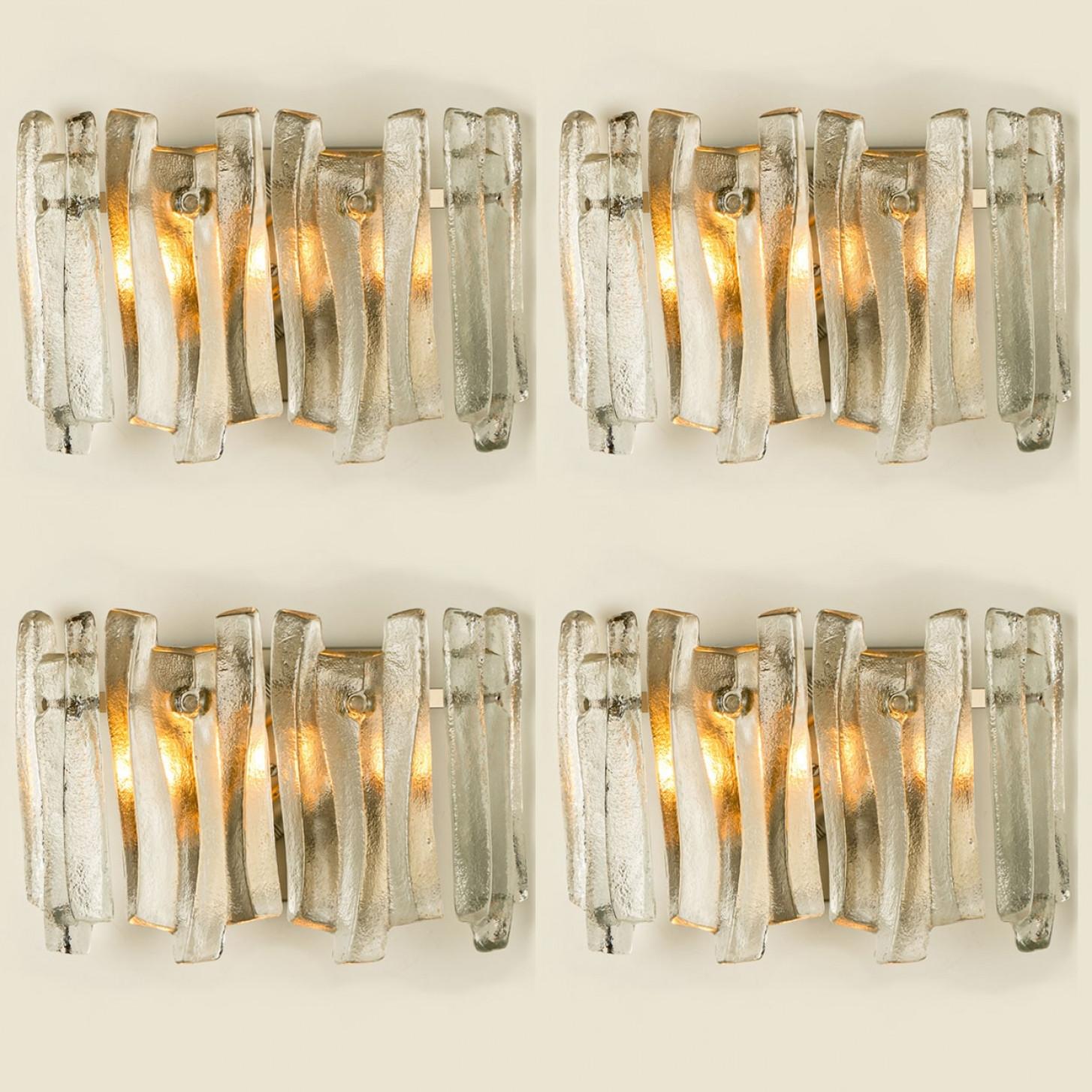 Preciosos y elegantes apliques modernos al estilo de Kalmar en la década de 1970. Un diseño precioso. Doce gruesas vigas de cristal texturizado en forma de onda orgánica. El cristal transparente tiene un aspecto helado y artesanal, creando un efecto