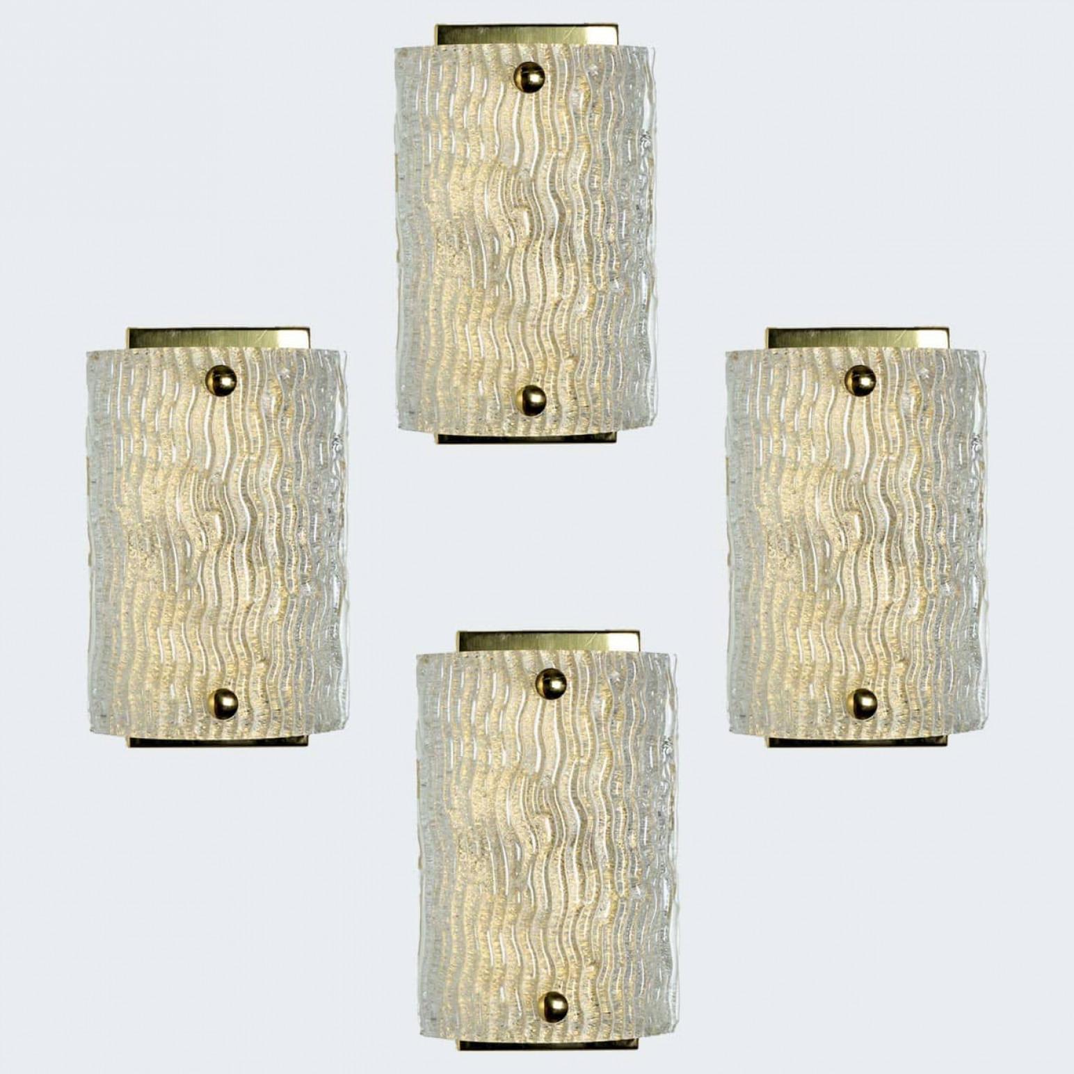 1 delle 4 bellissime lampade di alta qualità prodotte da Kalmar, Austria. Prodotto a metà del secolo scorso, circa 1970

Questa applique è caratterizzata da luci in vetro ondulato lavorato a mano e da una piastra posteriore in ottone. I lati