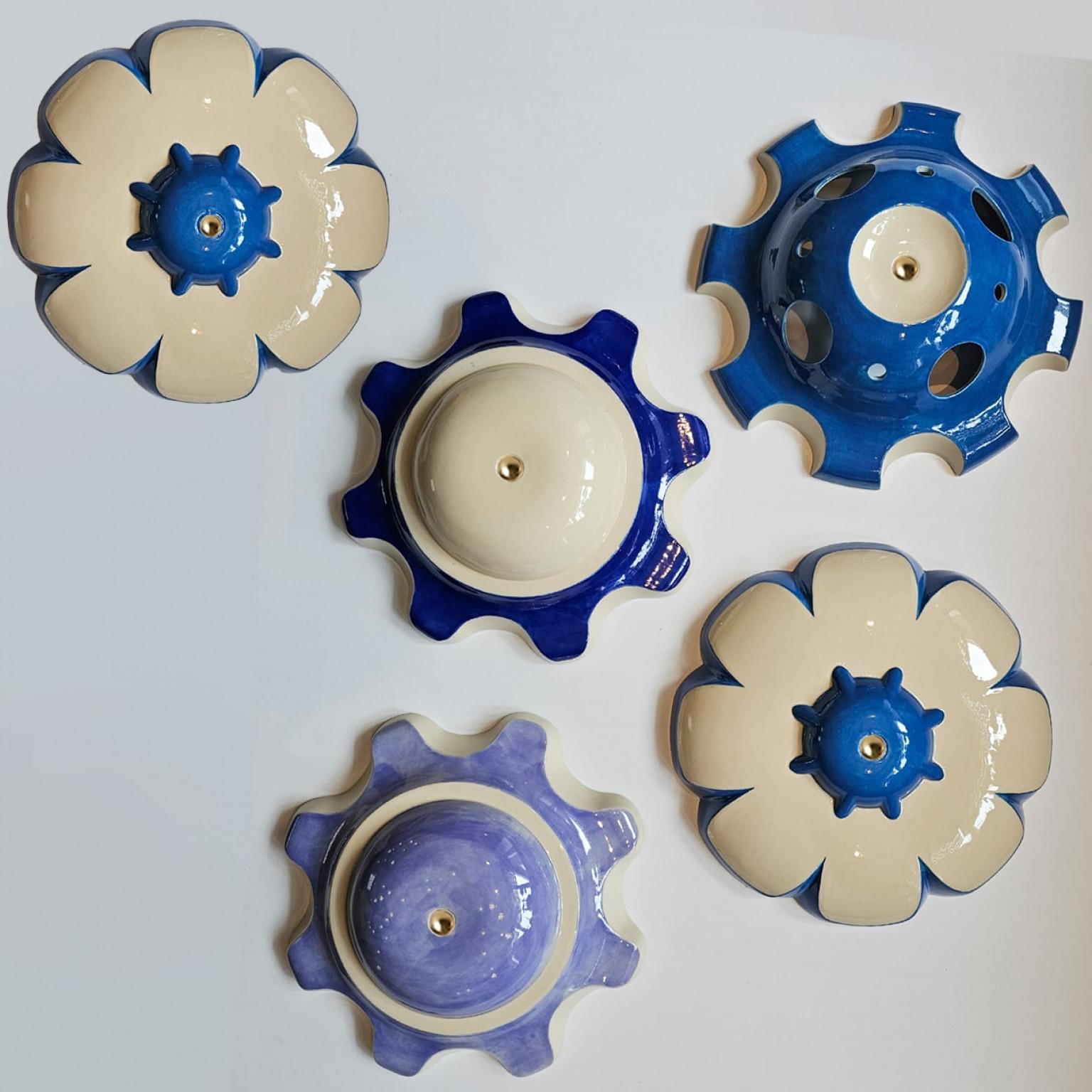 Unique hand-cast ceramic “rosettes” from Jeanine Keizer’s 1990s Lichtpuntje installation are reborn as sculptural pendant lamps. Each set groups five to seven pieces in harmonising colours, creating a gentle, child-friendly glow. The biomorphic