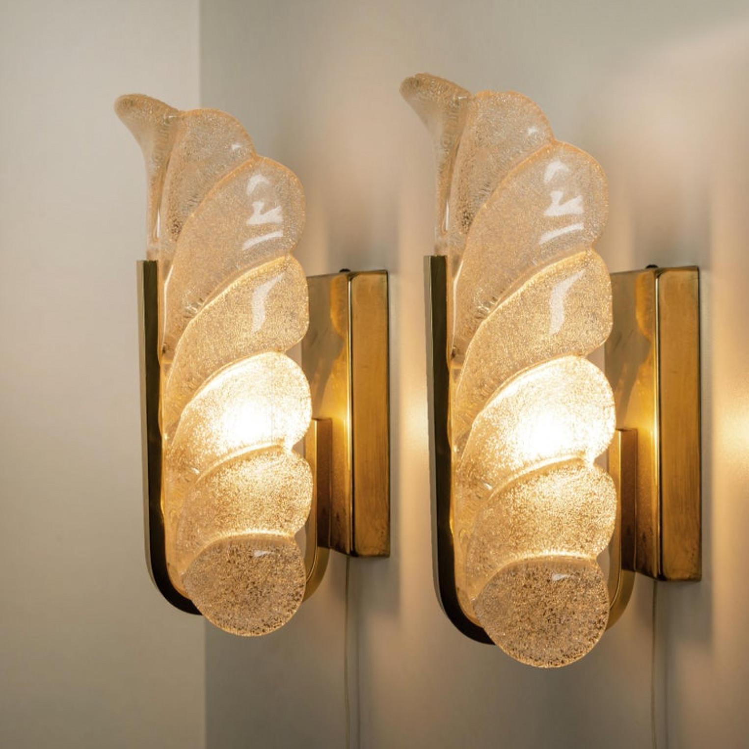 A beautiful large set of high end wall lights with one glass shade and brass frame. The light fixtures are produced in the 1960s by the iconic firm of Orrefors and designed by Carl Fagerlund.

Beautifully carved clear frosted glass shades in a leaf
