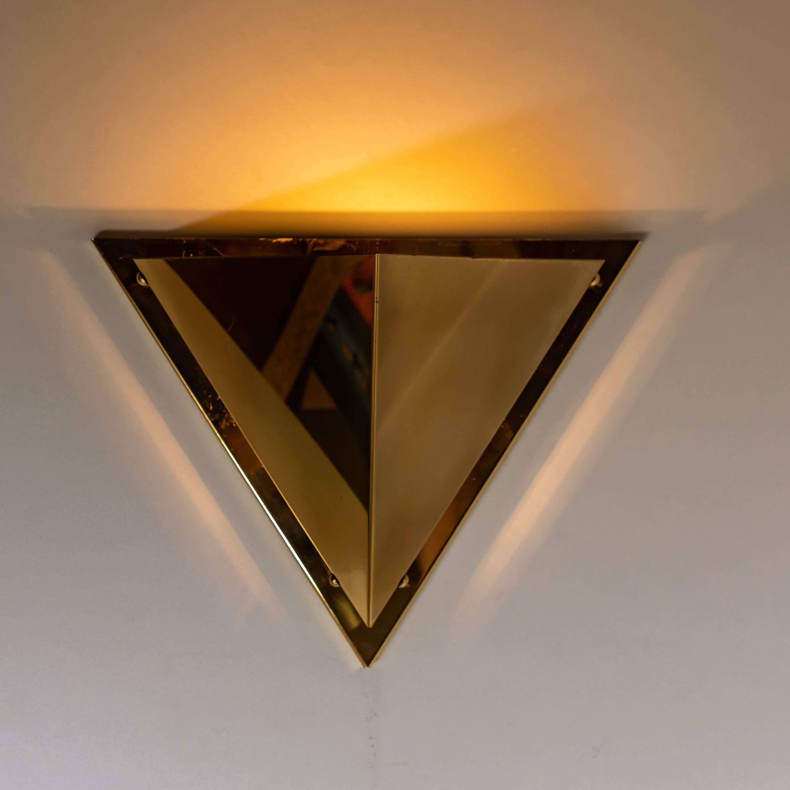 One of the five pyramid shaped brass wall lamps, 1970. Each wall light consist brass shades, which are held with brass screws on a brass frame. The wall light creates beautiful warm light partition upwards and on the side of the wall.

Please